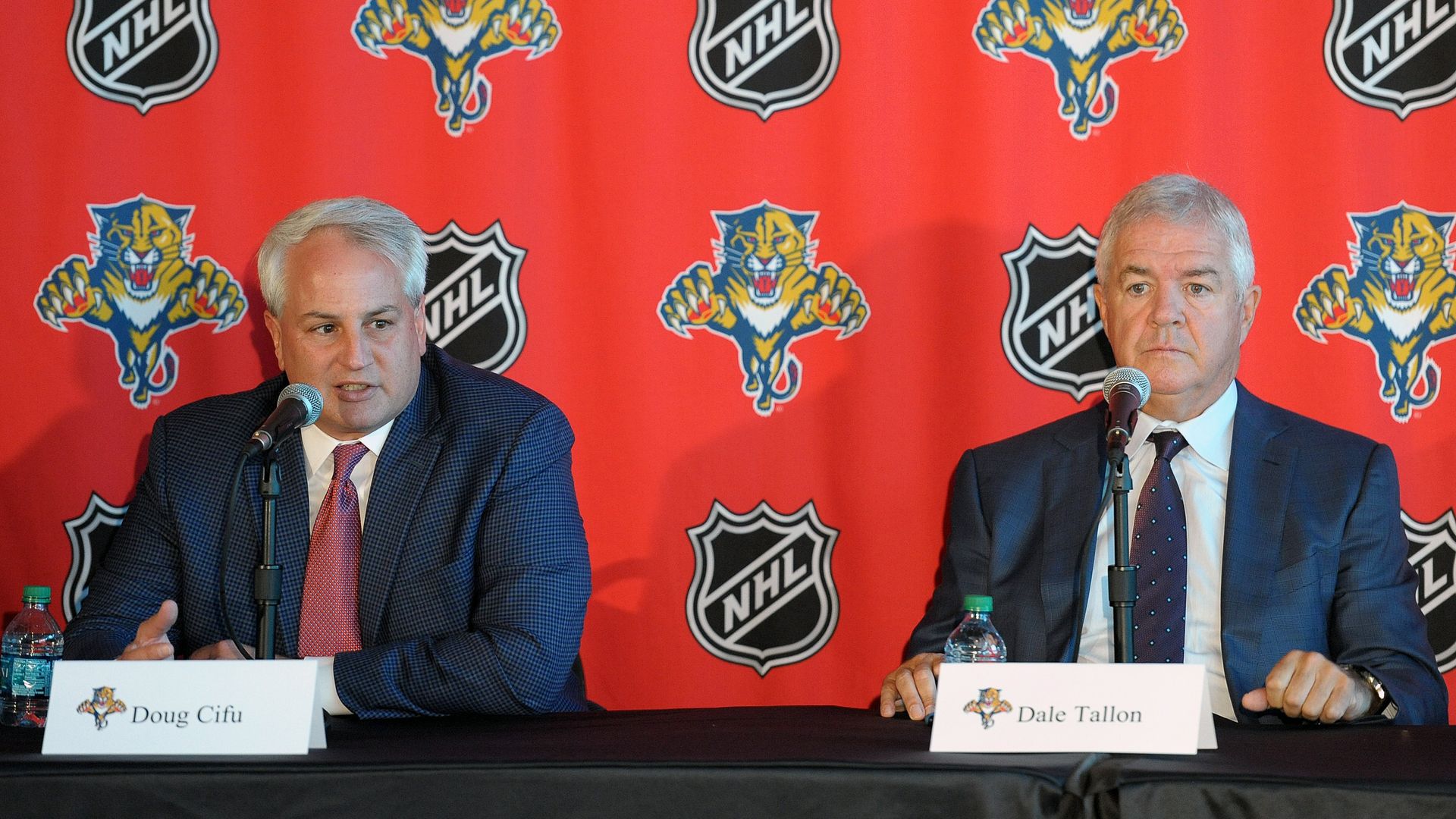 Two men sitting in front of microphones.