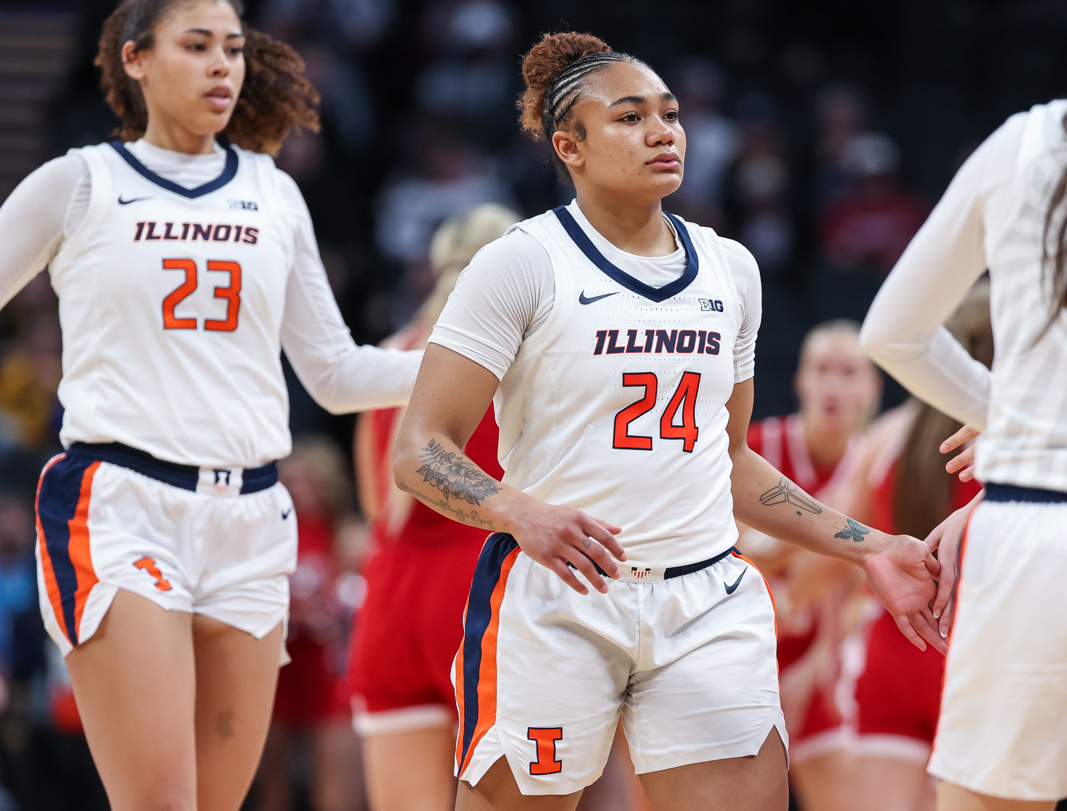 Photo of two women in basketball uniforms on a court.