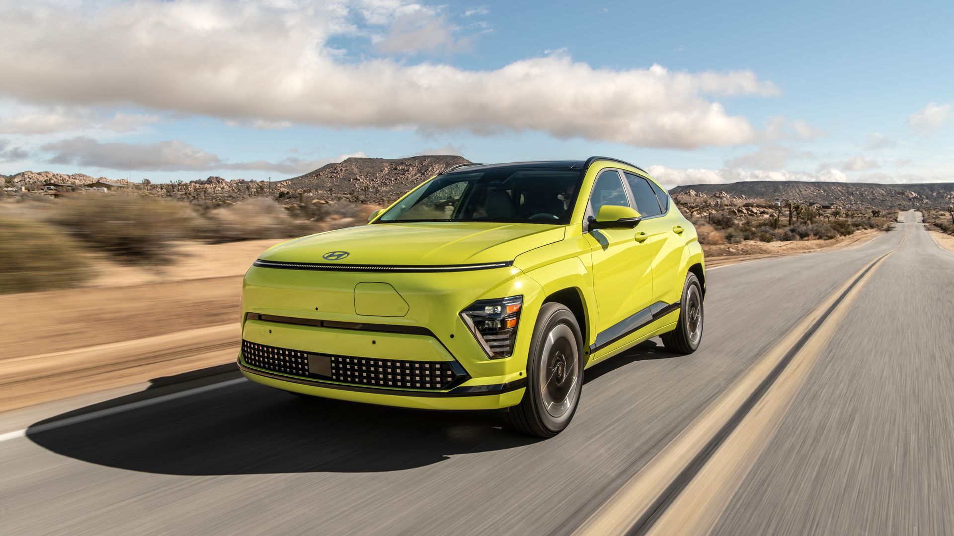Image of a bright yellow Hyundai Kona EV driving on a desert highway