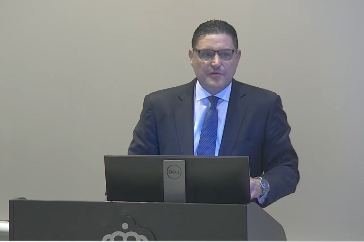 Man stands at a podium in a suit
