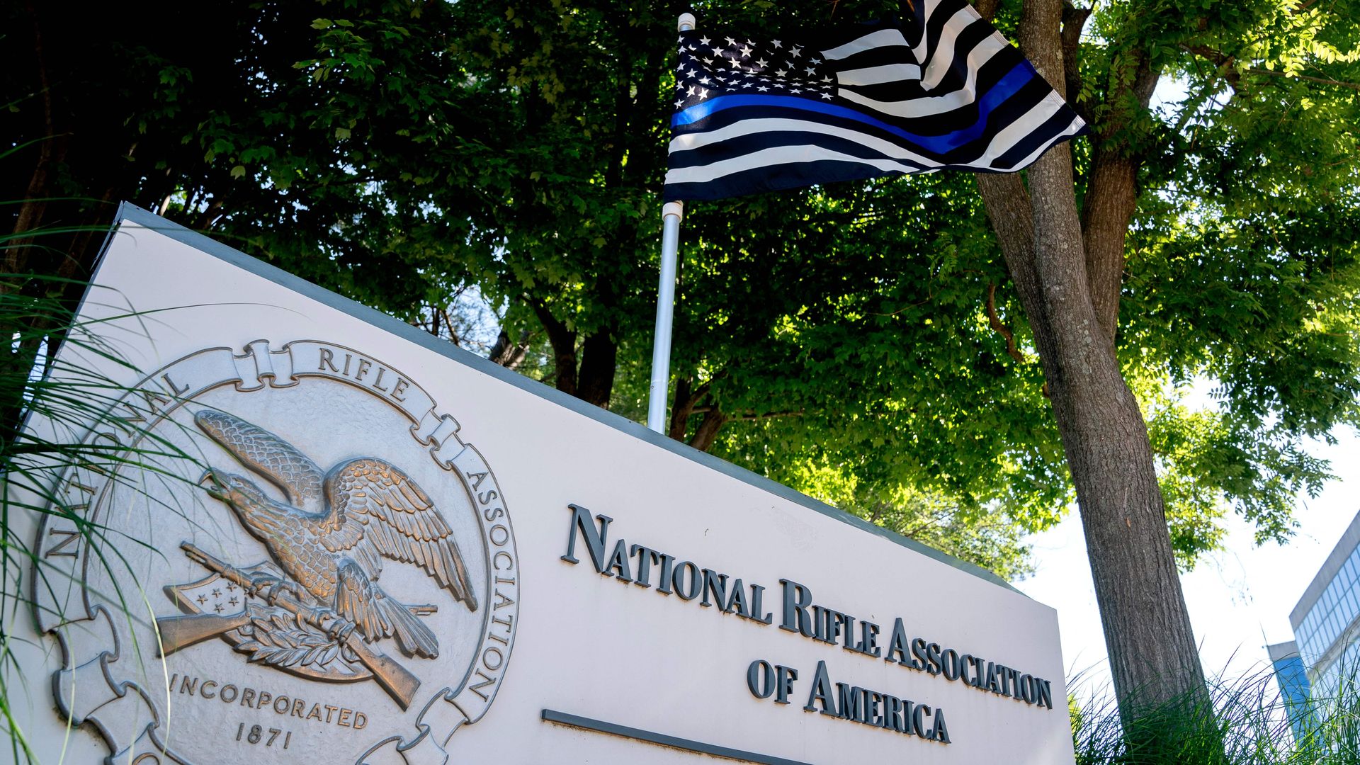 A thin blue line flag, signaling support for law enforcement, is displayed above the sign for the National Rifle Association (NRA) outside of its headquarters.