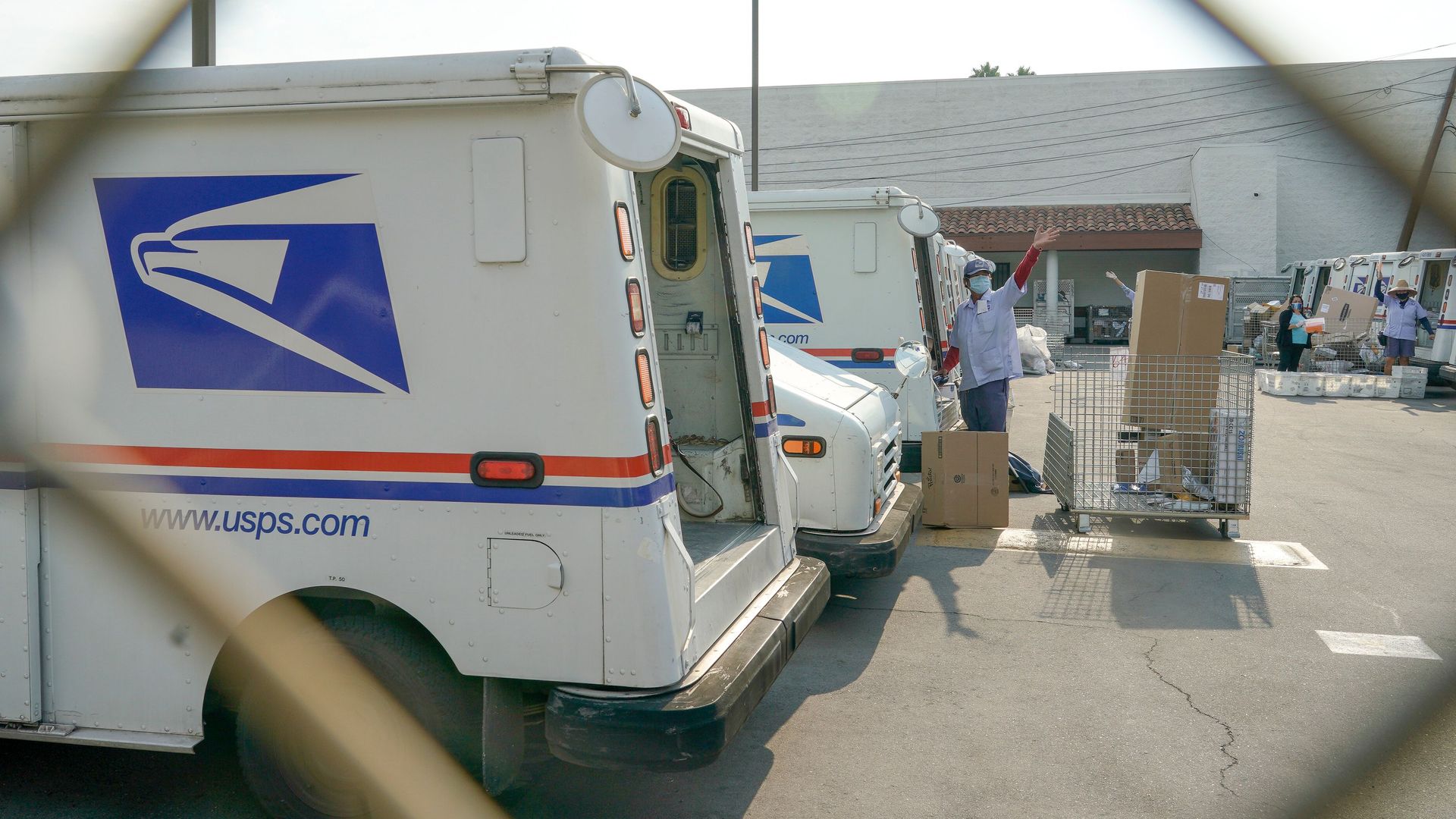 A postal worker waving in Los Angeles in August.