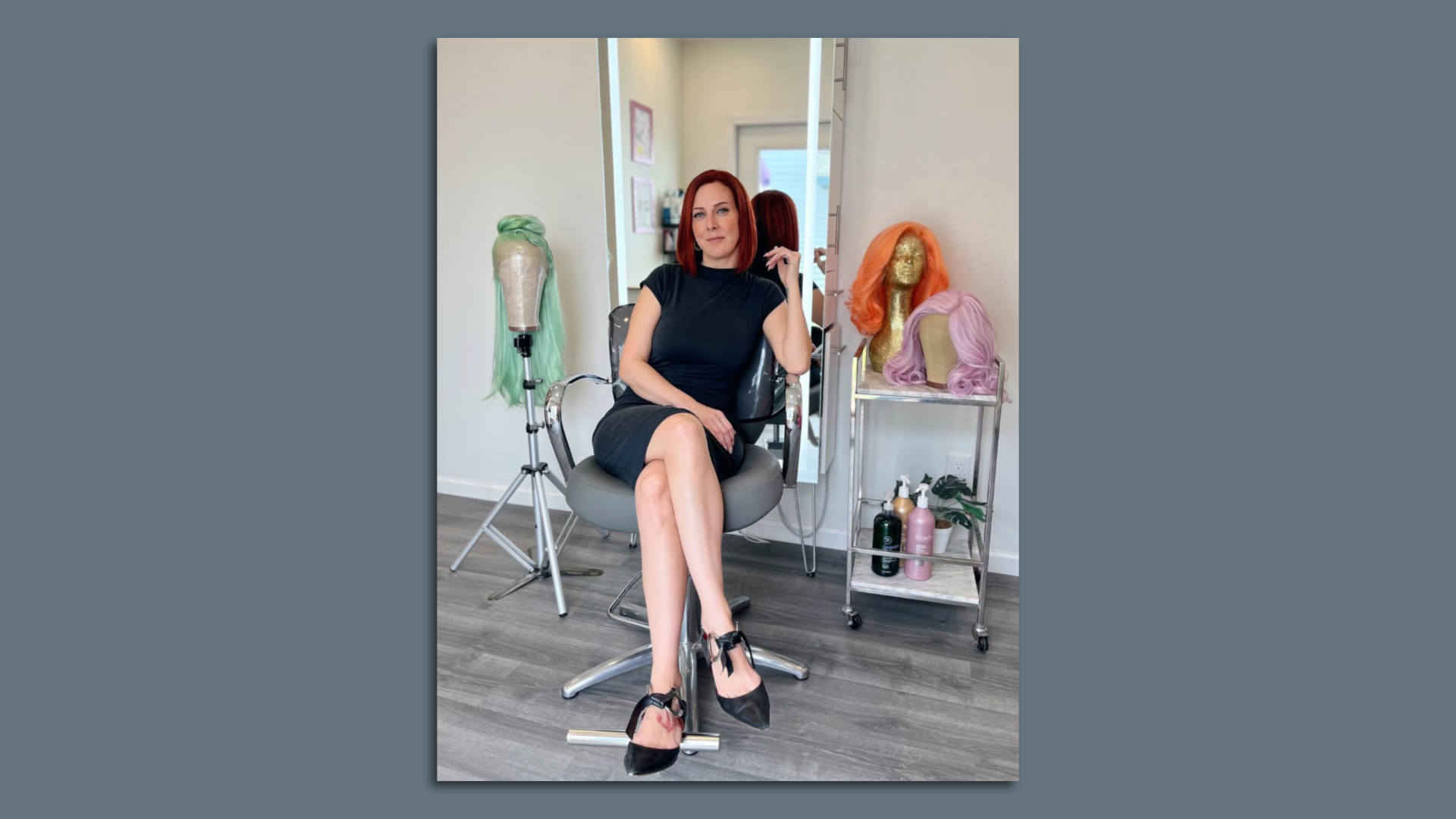Photo shows a woman sitting in a hair styling chair.