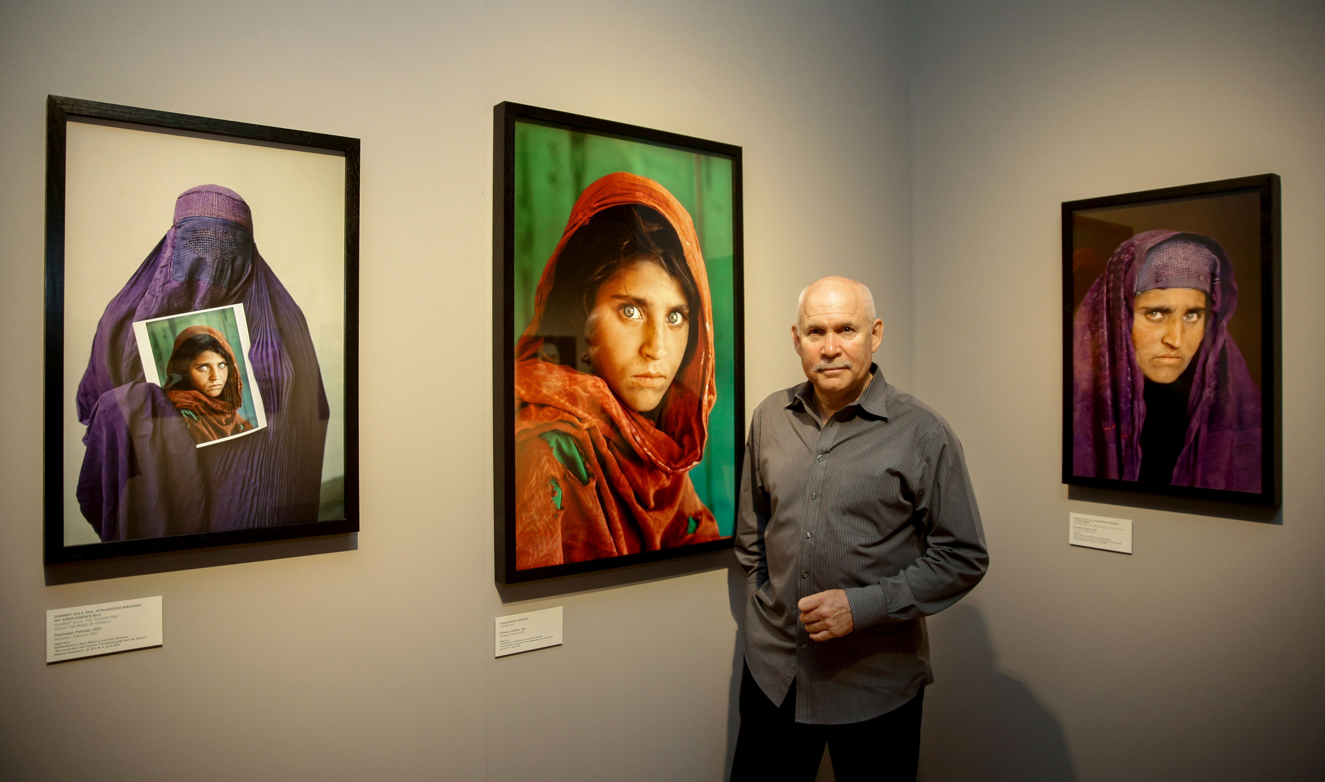 US photographer Steve McCurry poses next to his photos of the "Afghan Girl"