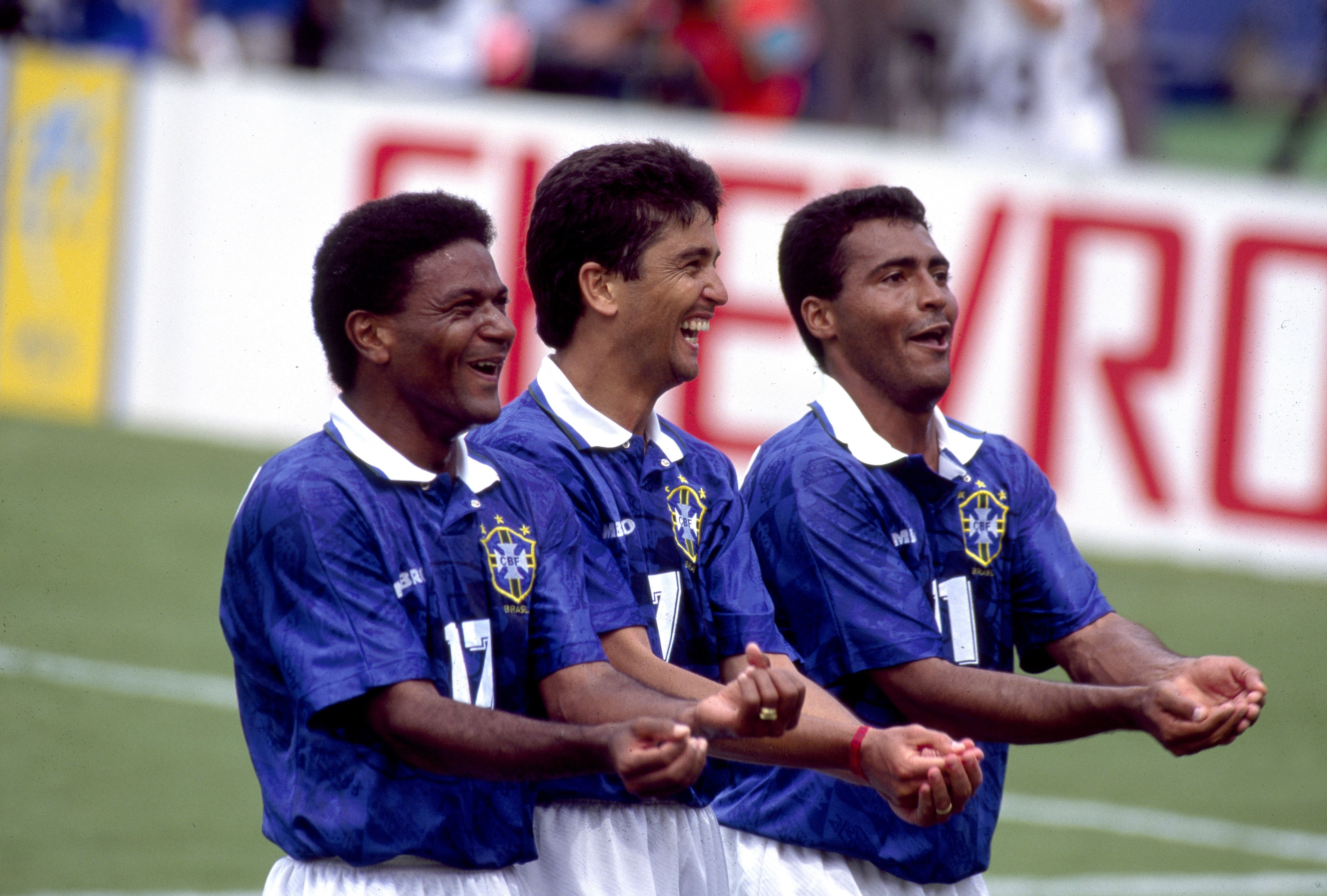 Three soccer players celebrating a goal