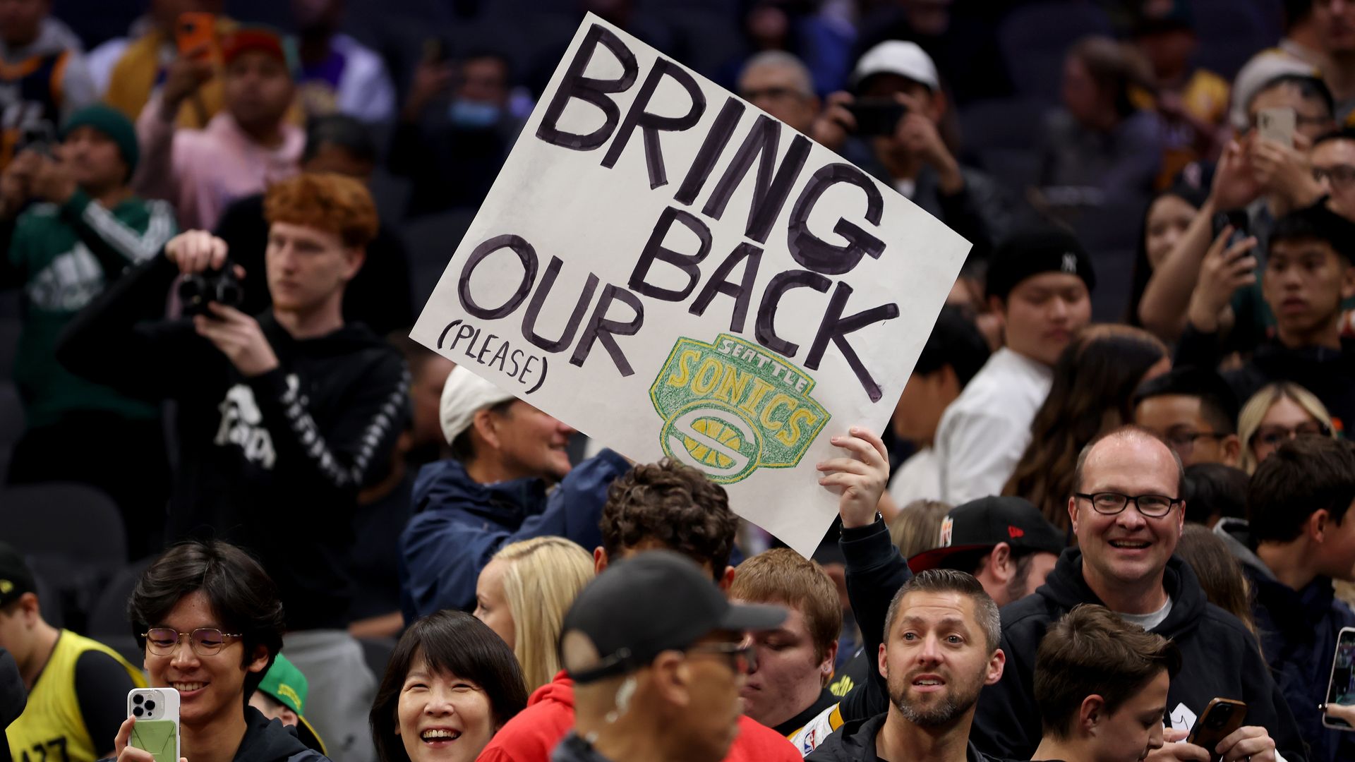 SEATTLE, WASHINGTON - OCTOBER 10: A Seattle Sonics fan holds a sign before the Rain City Showcase in a preseason NBA game between the LA Clippers and the Utah Jazz at Climate Pledge Arena on October 10, 2023 in Seattle, Washington. (Photo by Steph Chambers/Getty Images)
