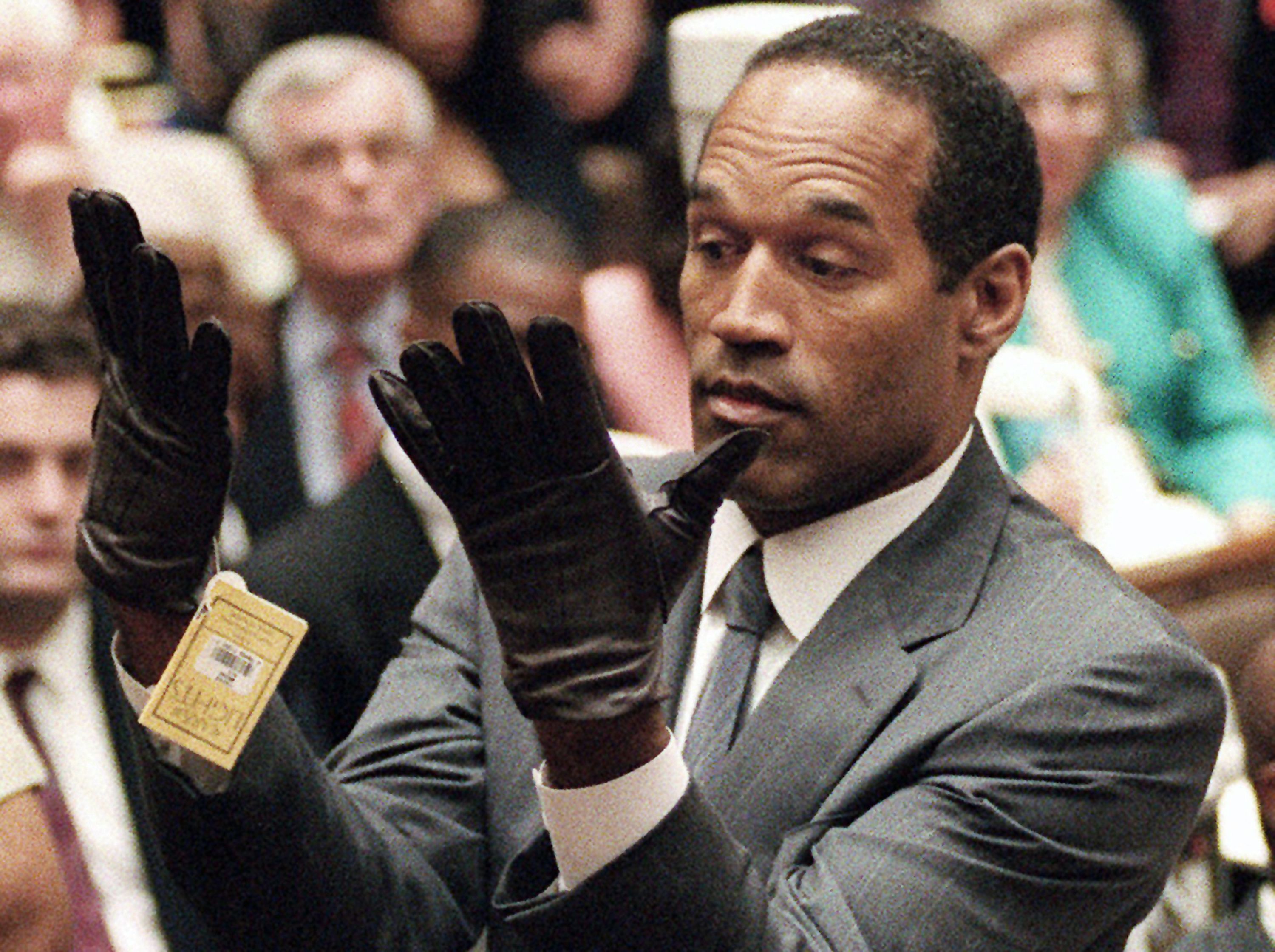 O.J. Simpson holds up his hands before the jury during the infamous "if it doesn't fit, you must acquit" moment.