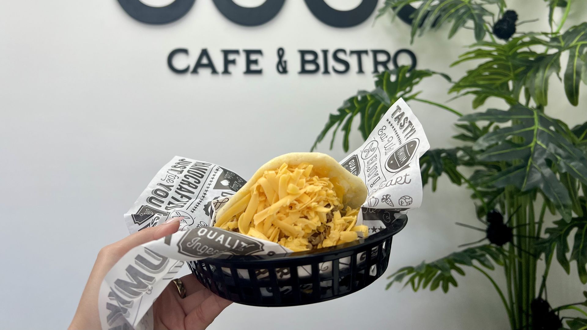 A hand holding up an arepa stuffed with yellow cheese