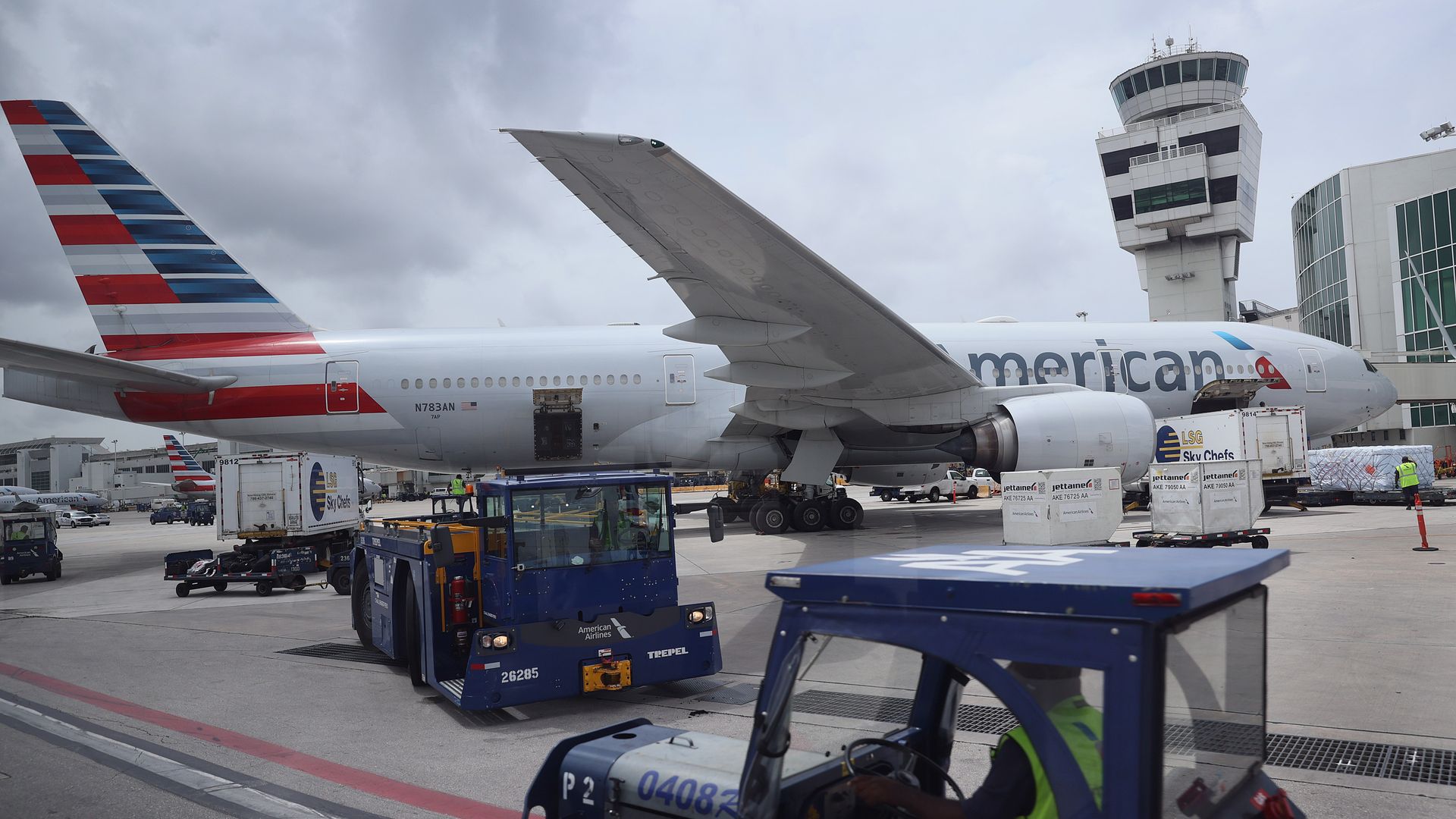 Workers prepare an American Airlines plane at a gate before its flight from the Miami International Airport on June 16, 2021 in Miami, Florida. 
