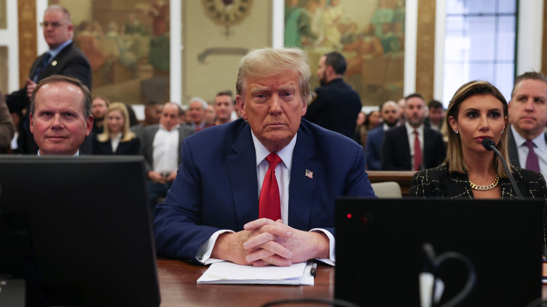 Donald Trump sits at a table in a courtroom with his lawyers