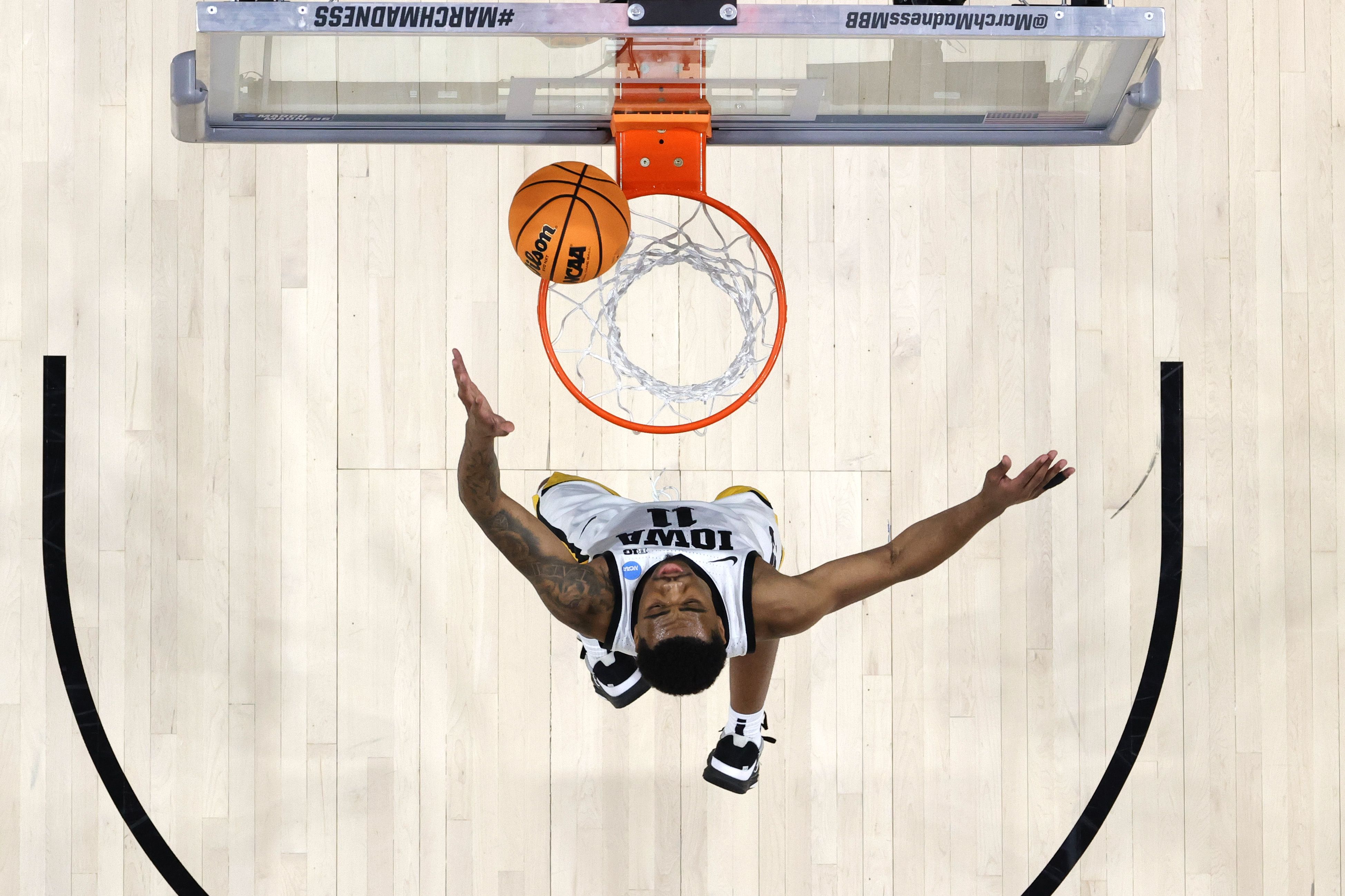 Photo of a man underneath the rim on a basketball court