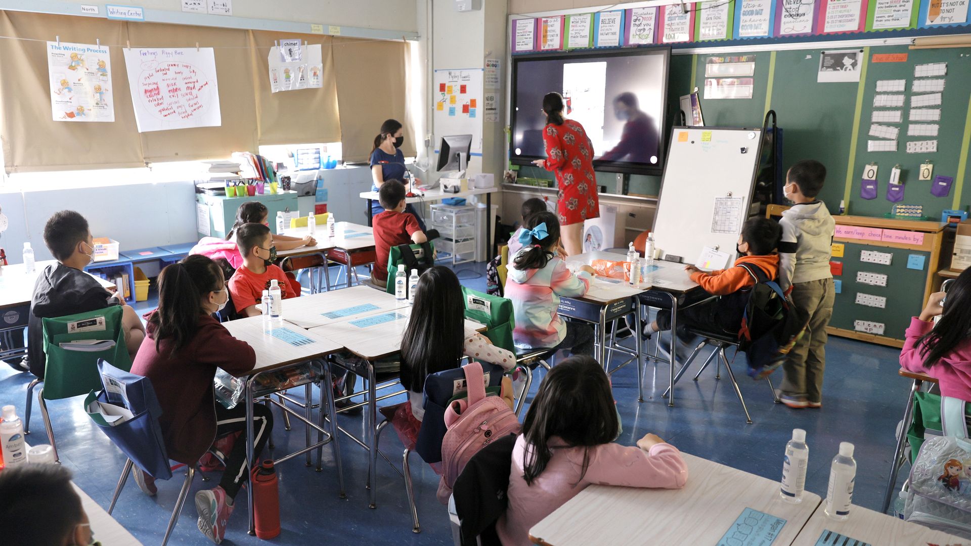 Co-teachers at Yung Wing School P.S. 124 Marisa Wiezel and Caitlin Kenny give a lesson to their masked students in their classroom on September 27, 2021 in New York City