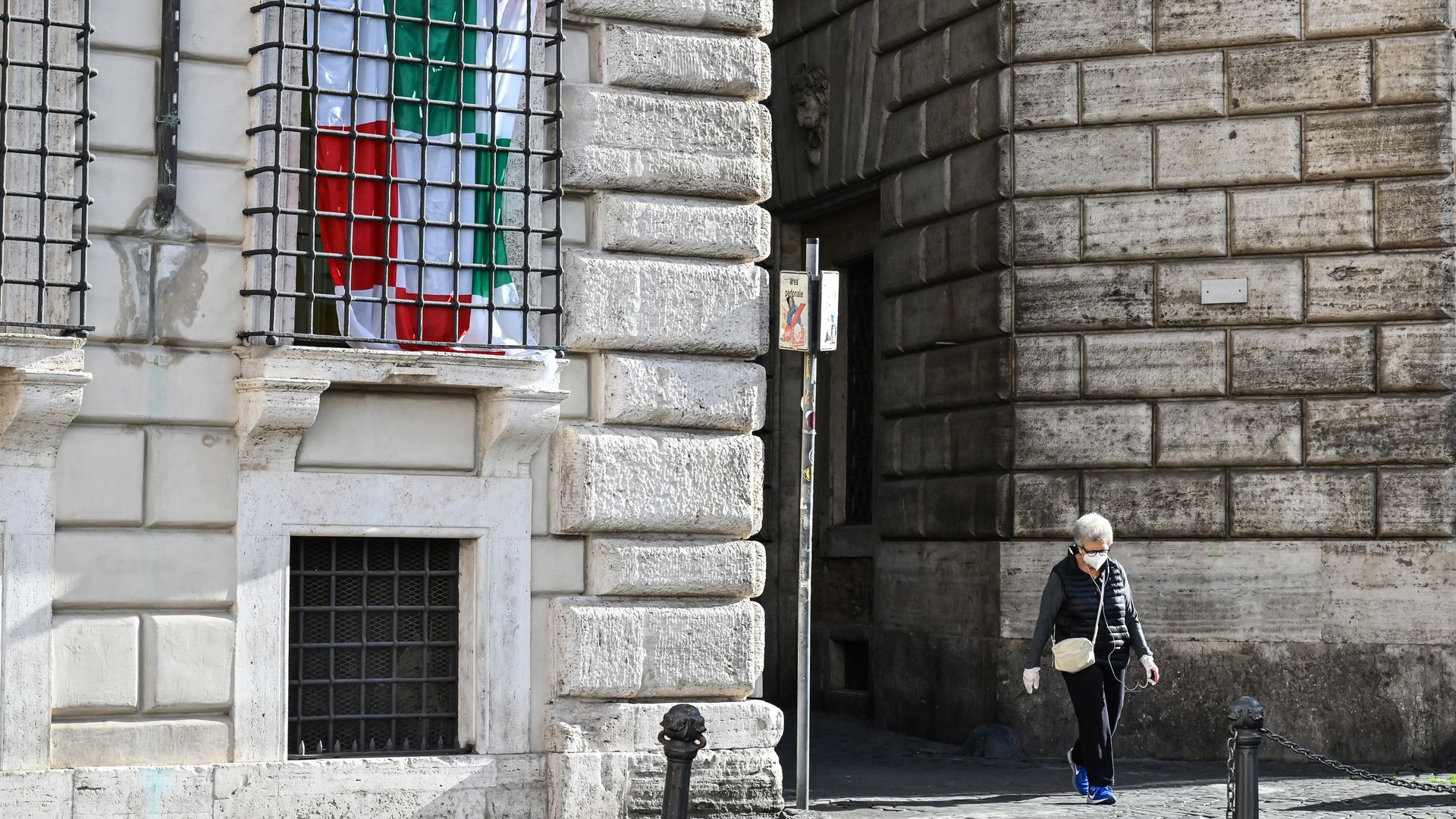 In this image, a person walks down a stone hallway 