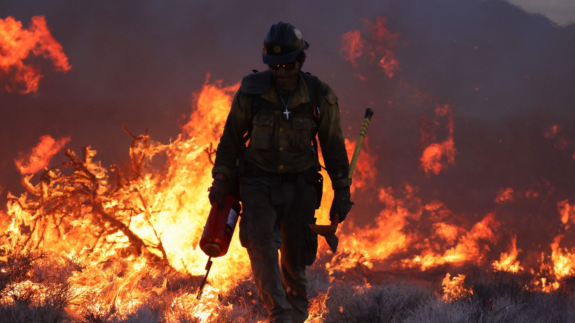 A firefighter sets a back-fire as the York Fire burns in the Mojave National Preserve on Sunday. 