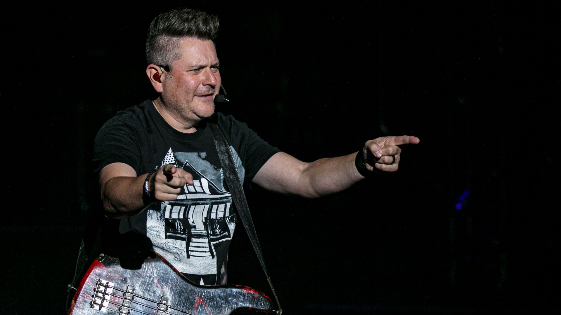 Jay DeMarcus points his fingers at a crowd
