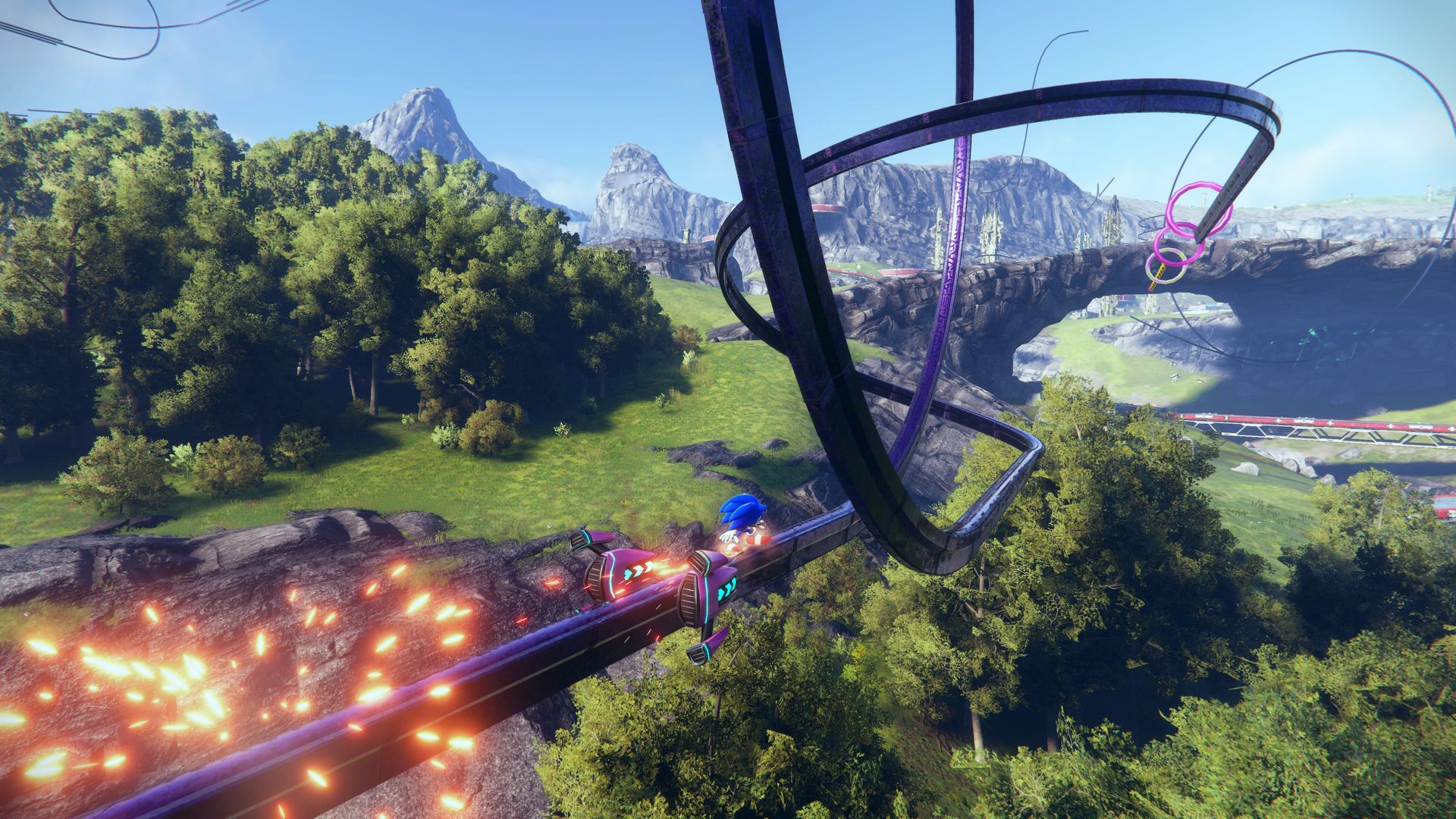 Video game screenshot of a Sonic the Hedgehog riding a looping grind rail over a forest