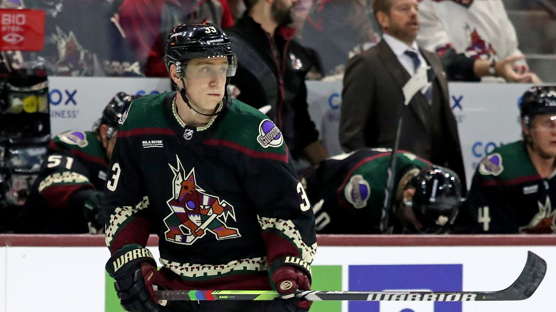 A hockey player with rainbow-patterned tape on his hockey stick. 