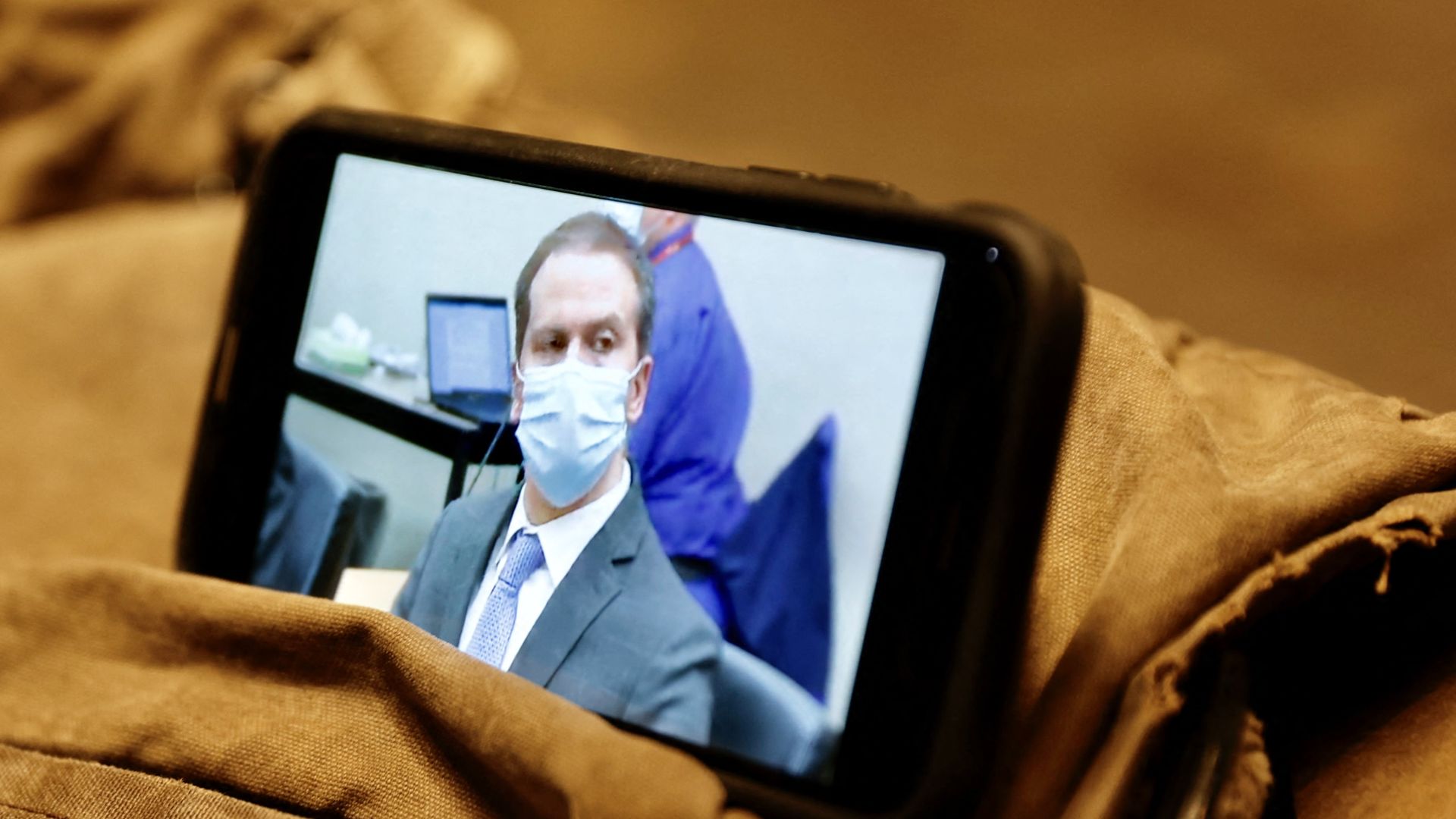 A journalist watches their mobile phone showing Derek Chauvin as the verdict in his trial over the death of George Floyd is announced in Minneapolis, Minnesota on April 20, 2021