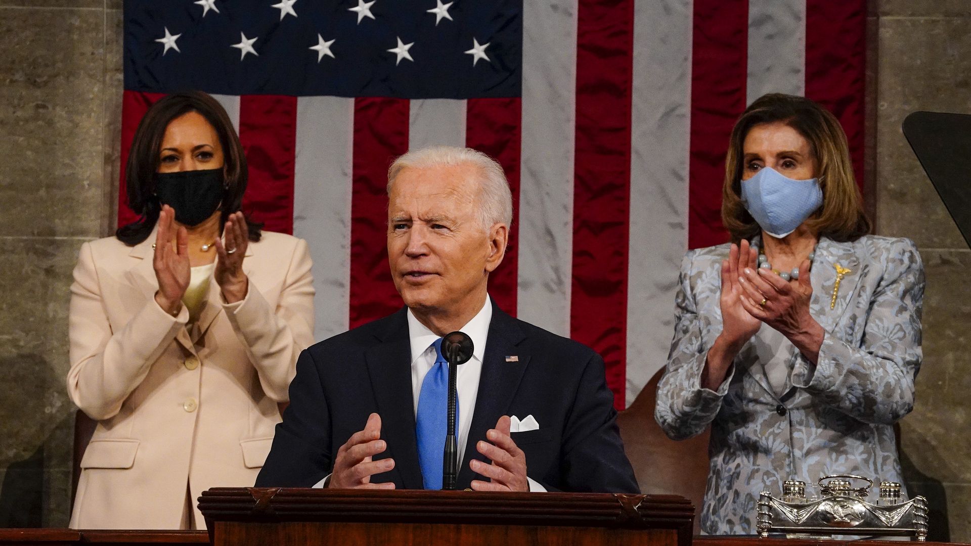 Joe Biden with Kamala Harris and Nancy Pelosi behind him