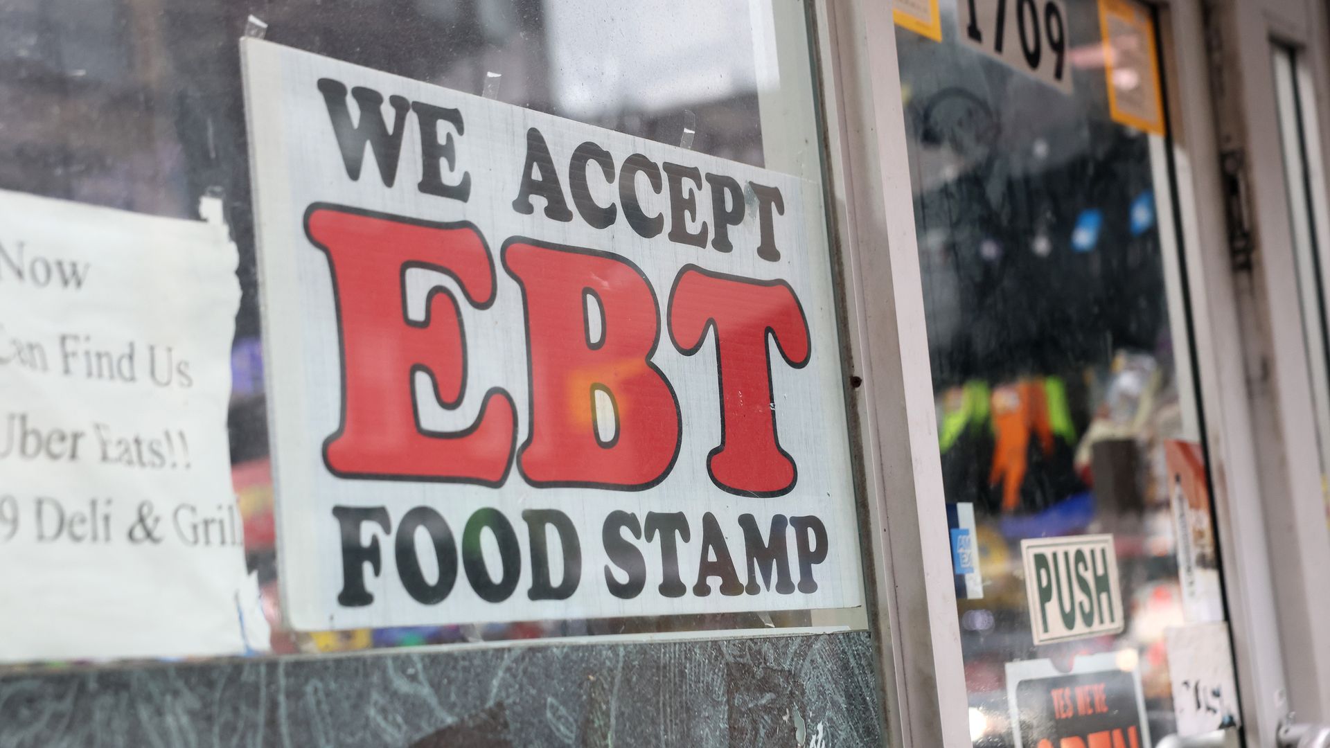 An EBT sign is posted on the glass window of a grocery store in Flatbush, Brooklyn.
