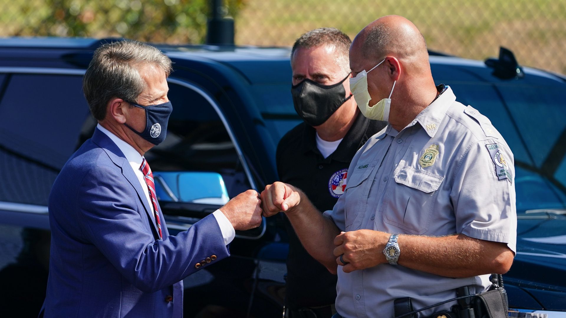 Georgia Gov. Brian Kemp fist-bumps an officer.