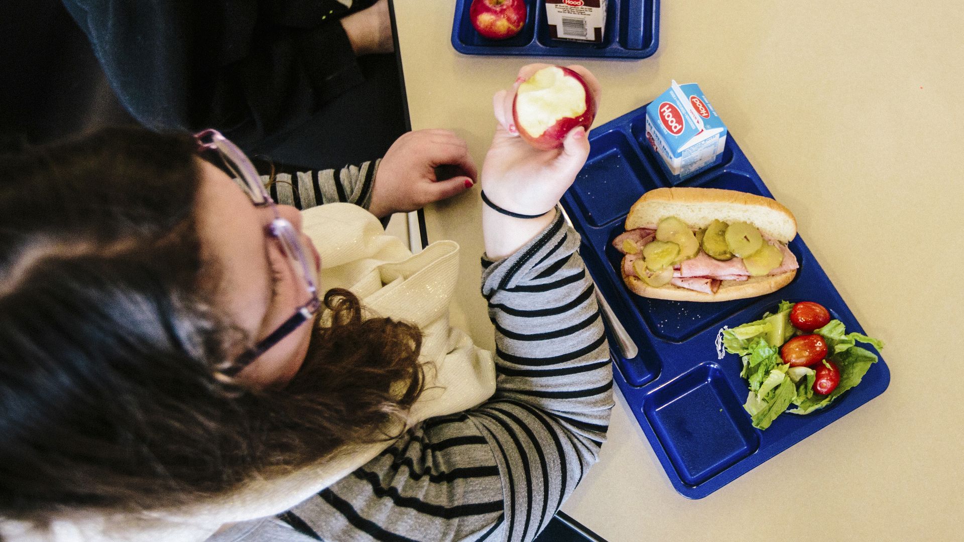 In this image, a student eats school lunch 