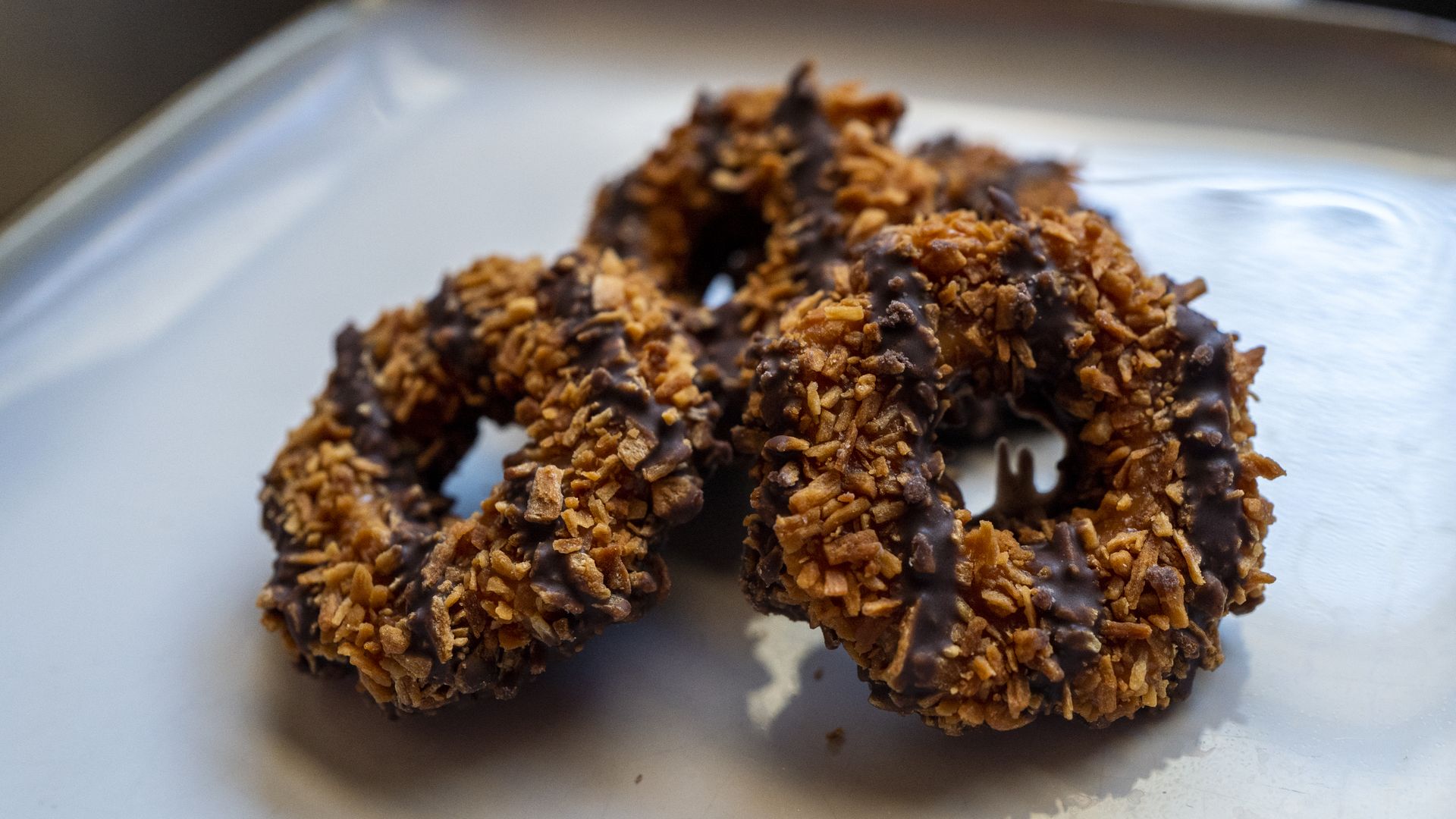 Three Samoa Girl Scout Cookies on a white plate.