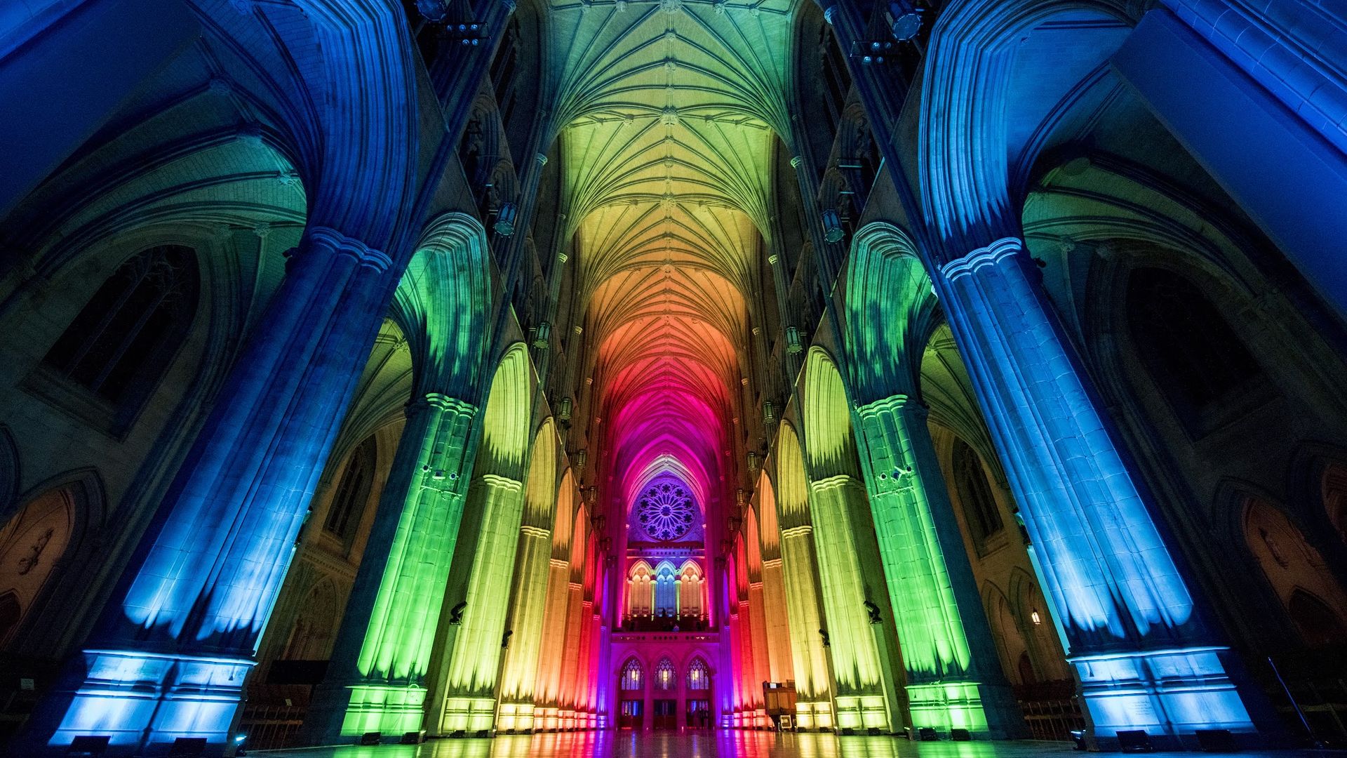 The National Cathedral's nave lit up in blue, green, orange, pink and purple.