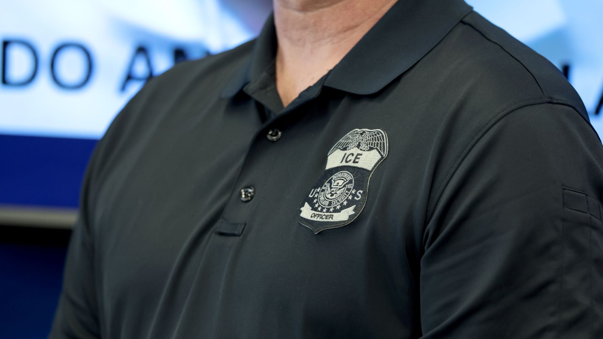 A photo of a person's polo shirt with the ICE logo