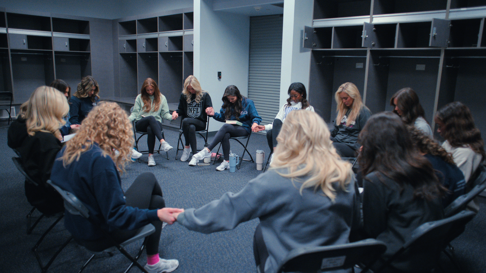 The Dallas Cowboys cheerleaders sit in a prayer circle 