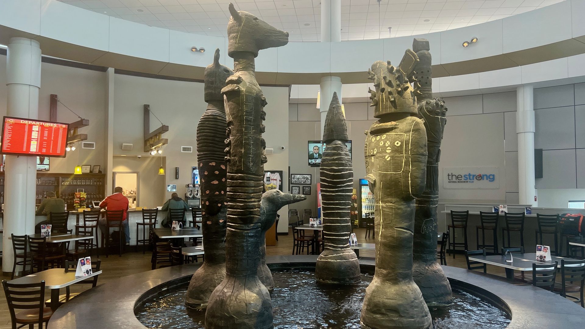 Four clay structures depicting animal heads on the top, all in a water pond