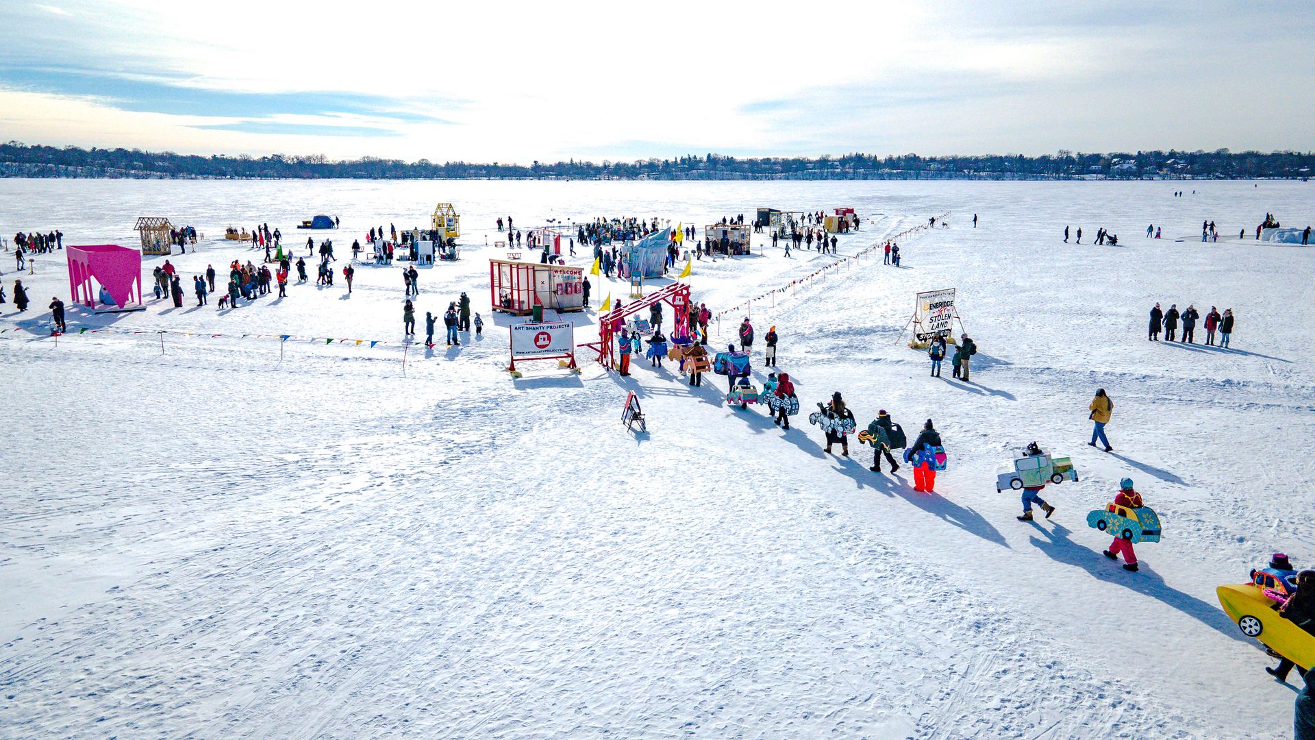 A large group of people gathered on a frozen lake.