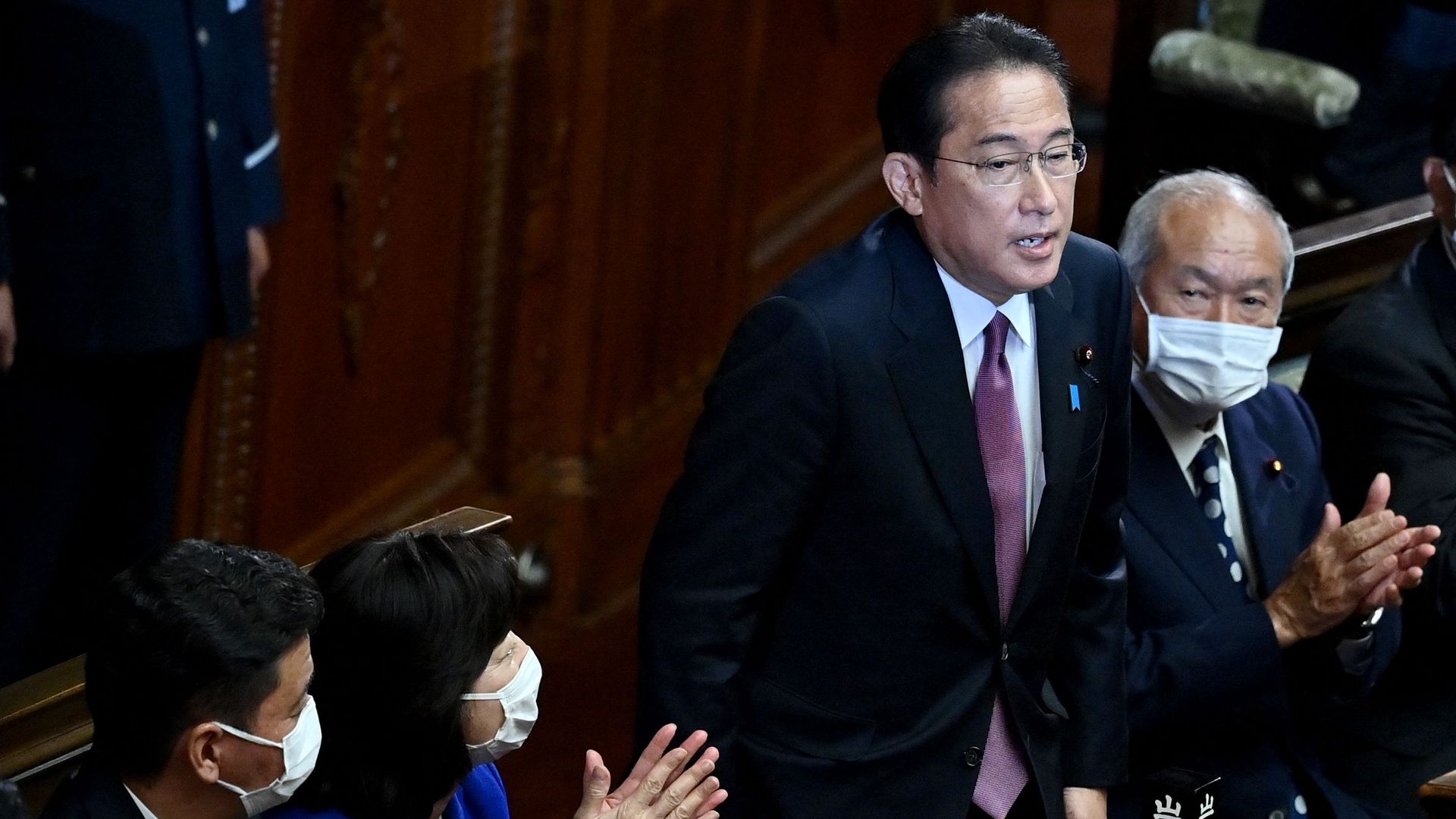 Japan's Prime Minister and leader of ruling Liberal Democratic Party Fumio Kishida (2nd-R) is applauded after being re-elected as PM in Japan's parliament, in Tokyo on November 10