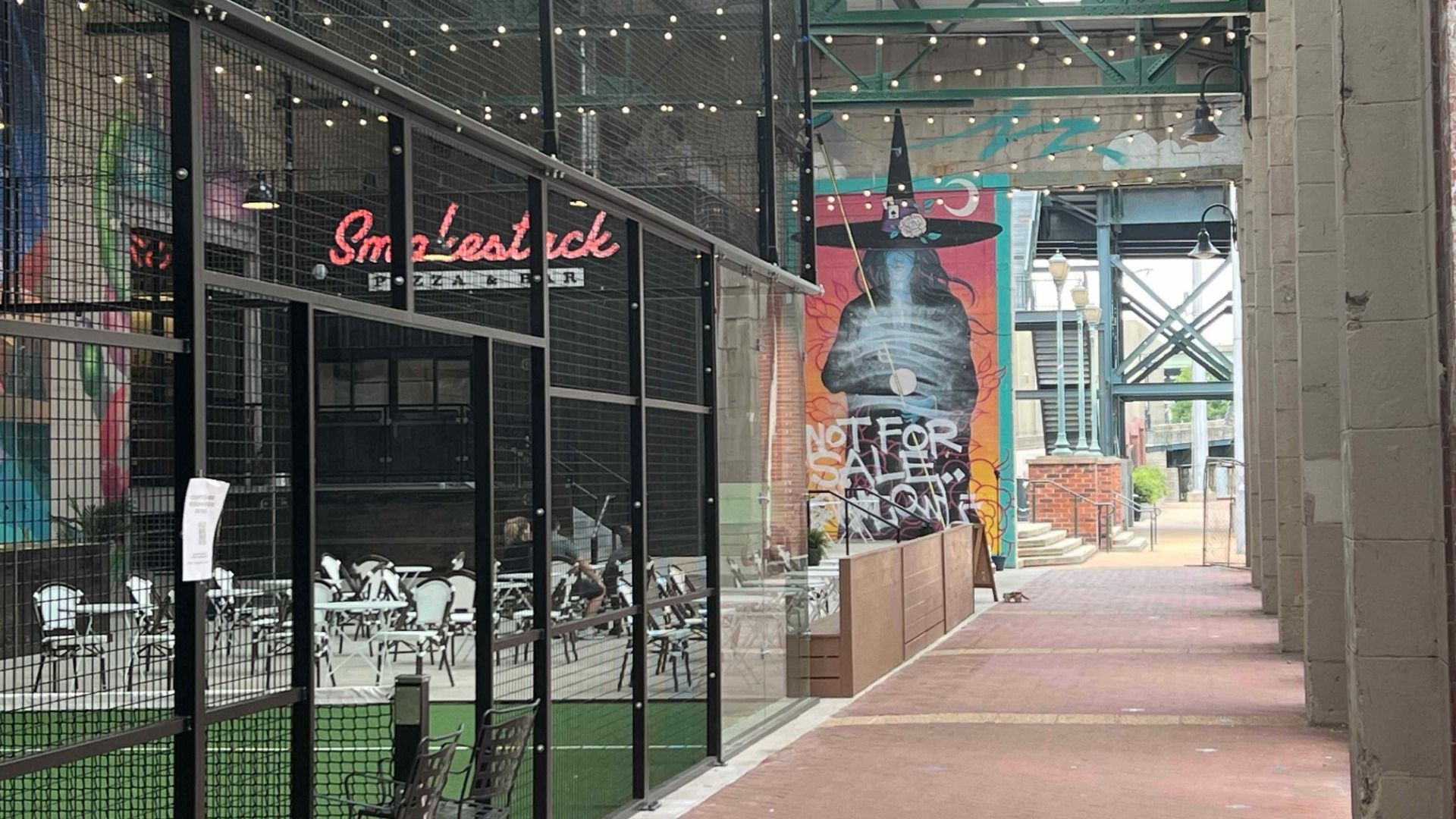 some courts next to murals, a pizzeria, and a canal