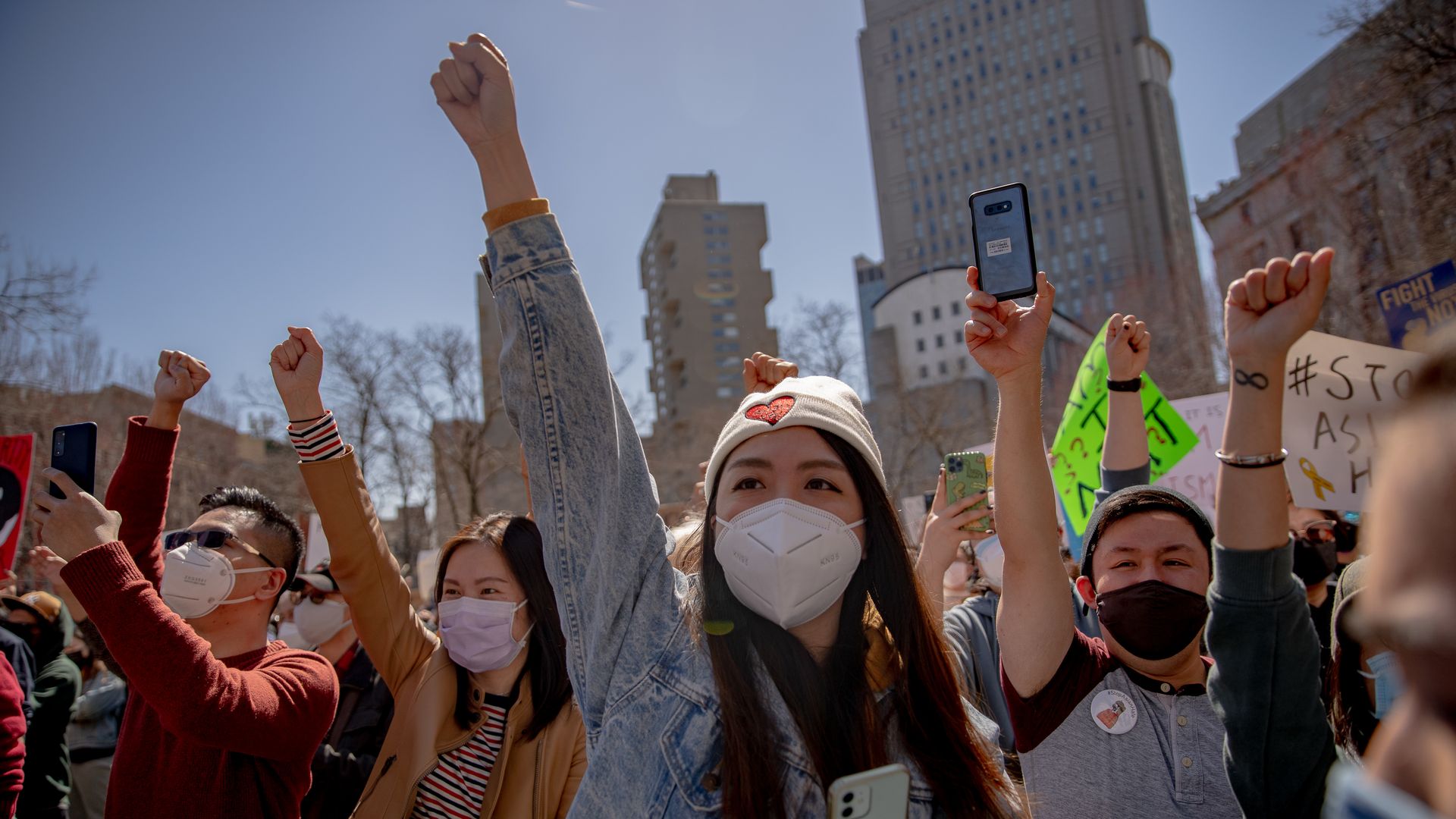 Demonstrators raise their fists during an AAPI Rally Against Hate in New York, U.S., on Sunday, March 21, 2021