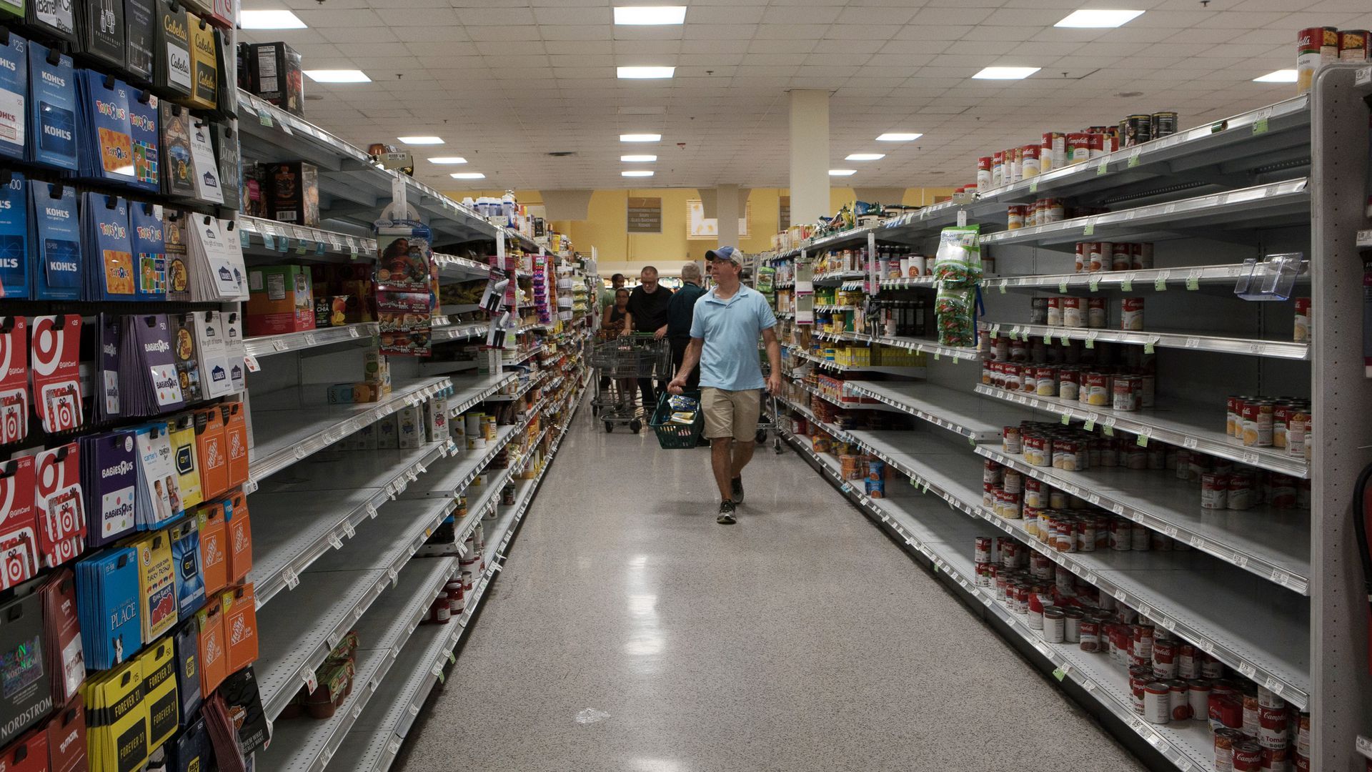 Customers browse near empty shelves at a Publix store ahead of Hurricane Irma in Miami on Sept. 6, 2017. 