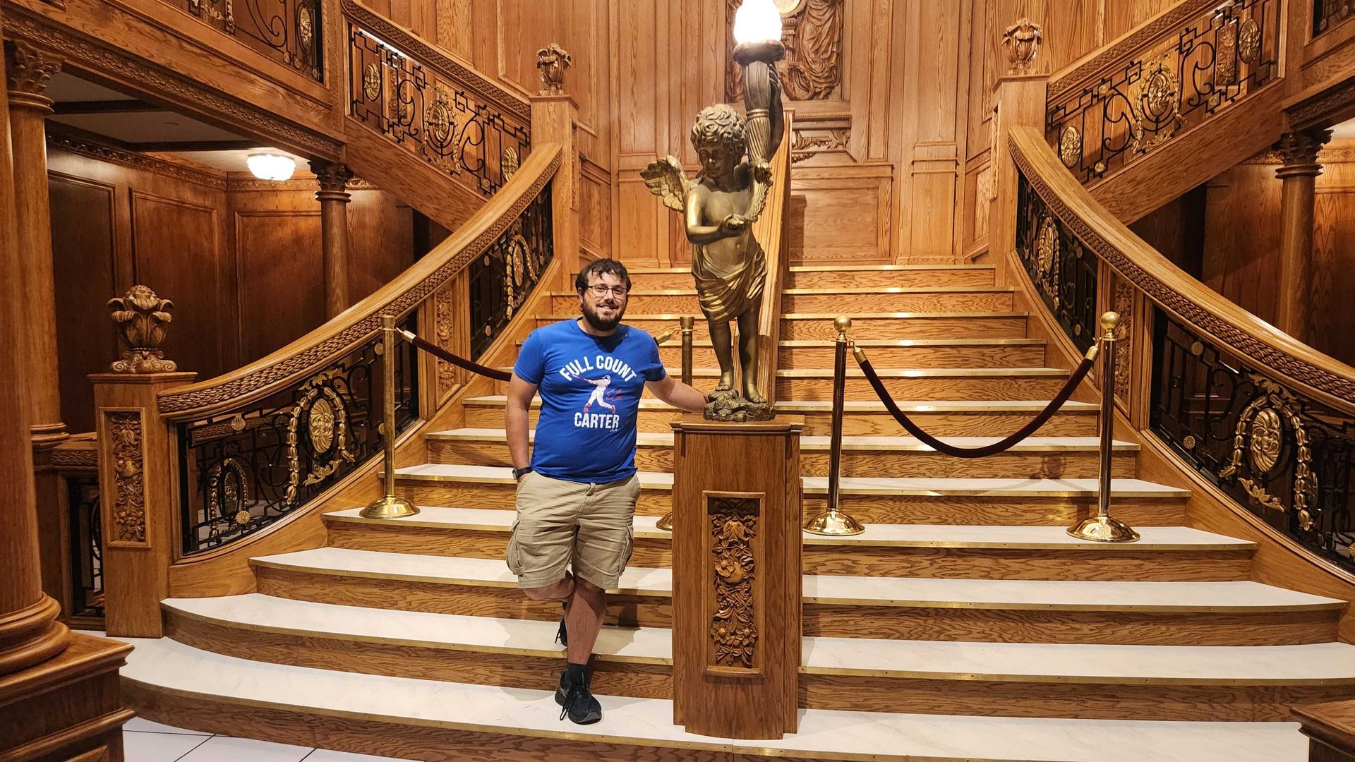 Tyler stands at the bottom of a recreation of the Titanic ship's grand staircase.