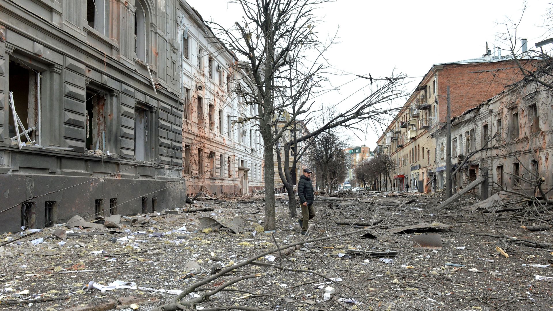 A pedestrian walks amid debris in a street following a shelling in Ukraine's second-biggest city of Kharkiv.