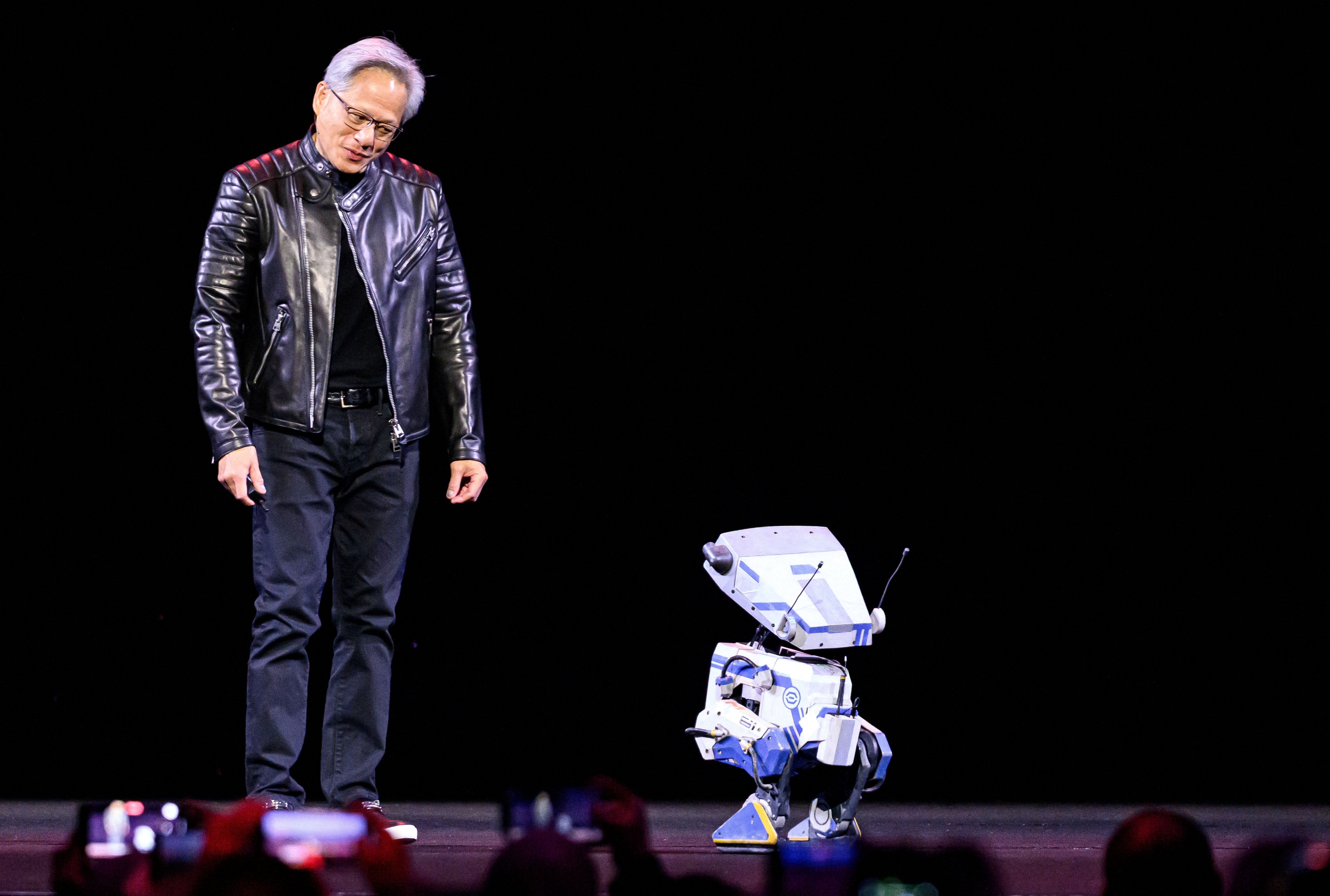 Nvidia CEO Jensen Huang talks to a robot during a keynote session at the SAP Center in San Jose, California on March 18, 2025. (Photo by JOSH EDELSON / AFP) (Photo by JOSH EDELSON/AFP via Getty Images)