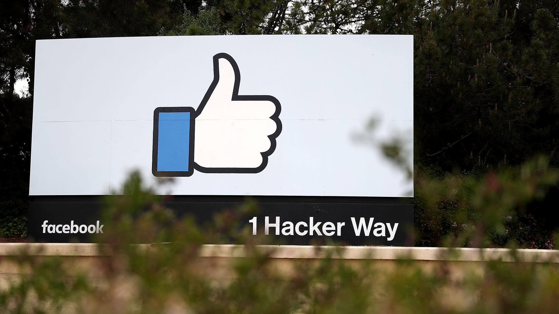 Photo of billboard outside Facebook headquarters with "like" icon and "1 Hacker Way" address