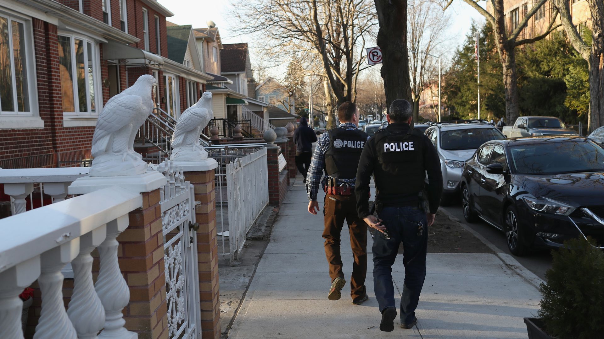 Two police officers walk through a neighborhood