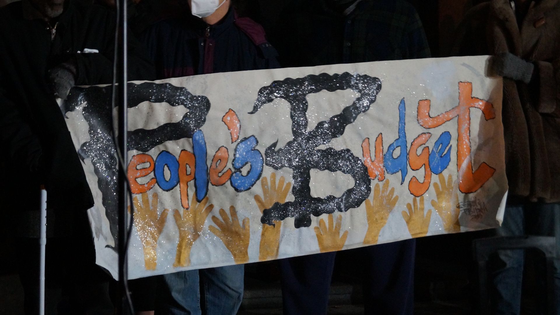 A handmade sign reading "People's Budget"