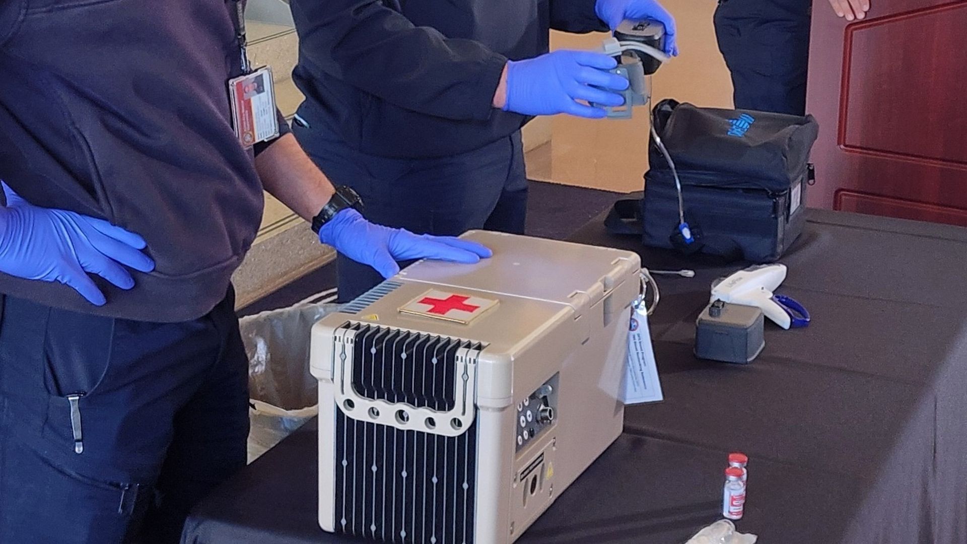 A gray box with a red health cross sits on a table