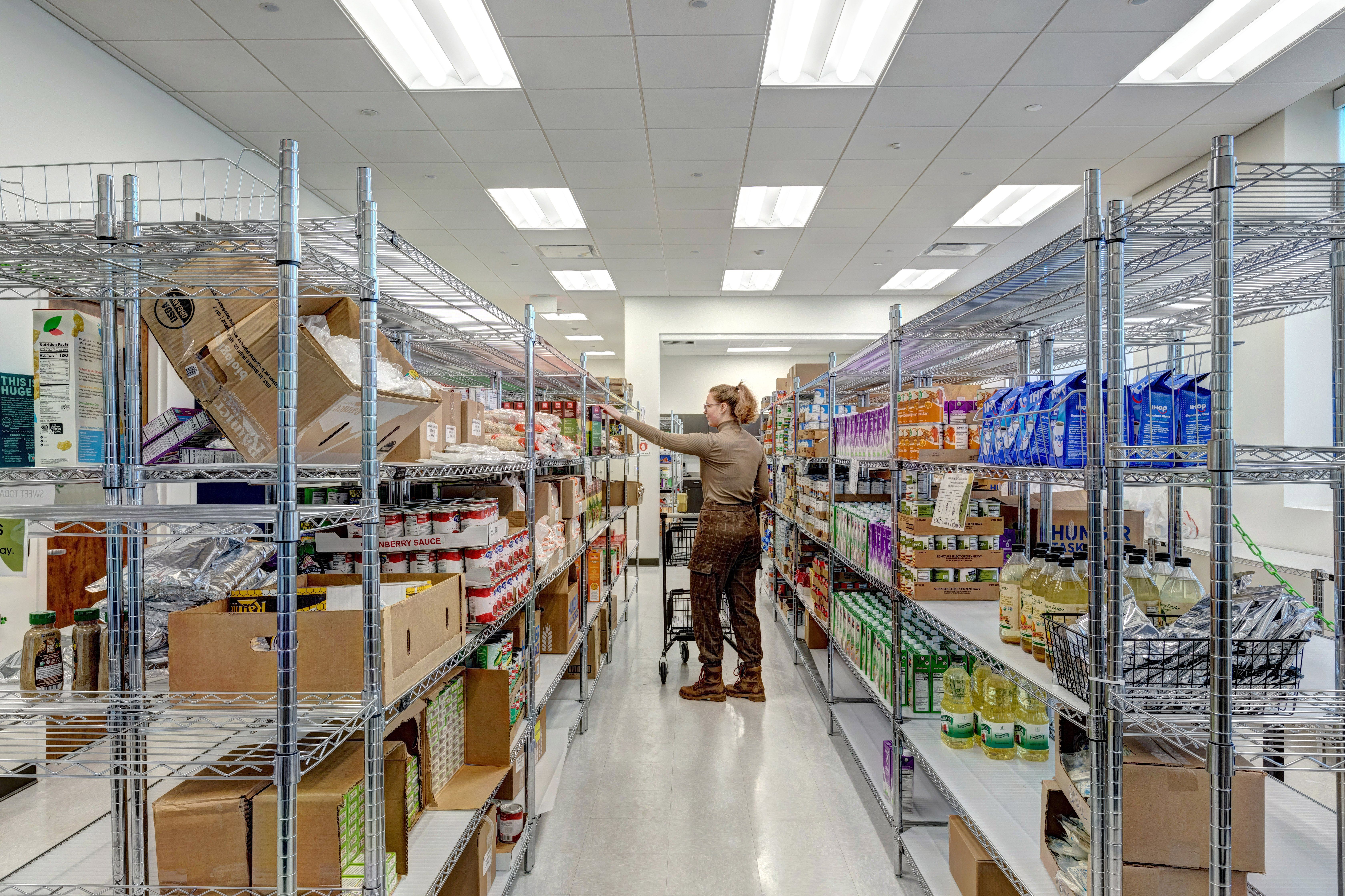 Person browsing the shelves at a food pantry.
