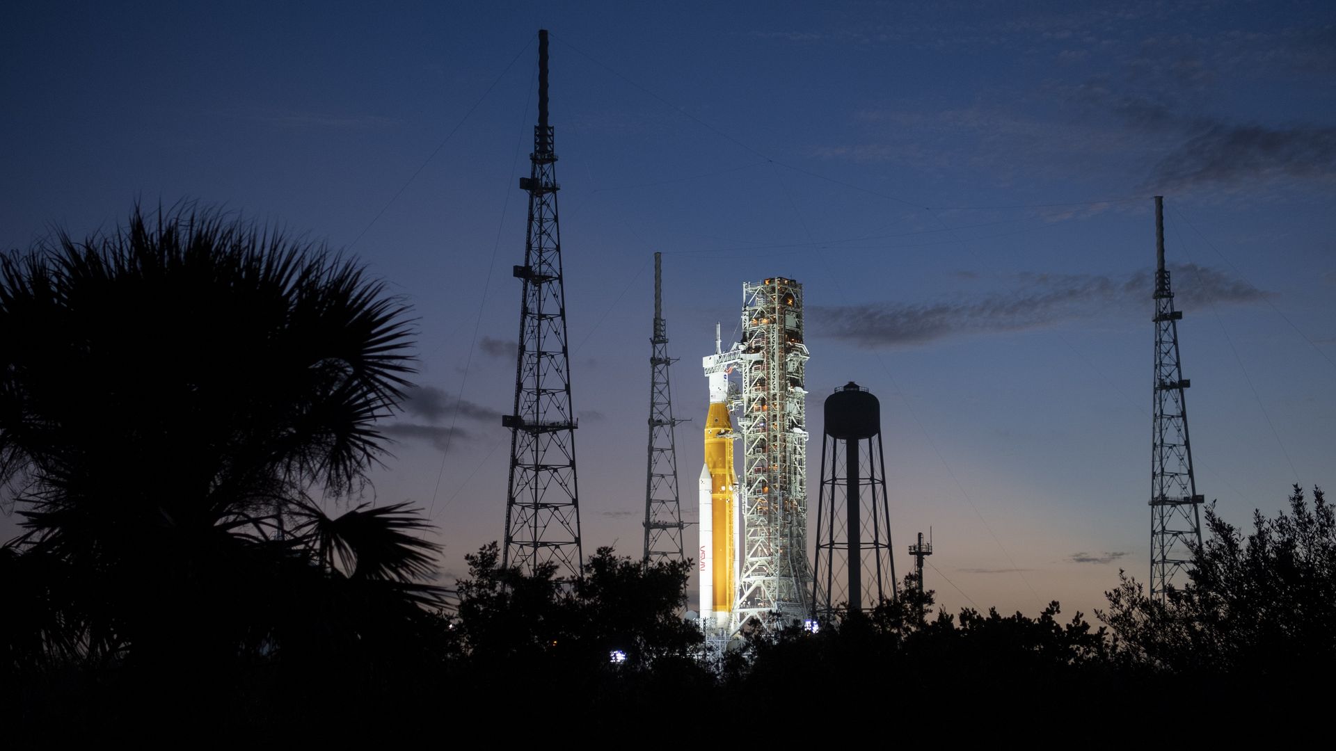 NASA's Space Launch System (SLS) rocket with the Orion spacecraft aboard is illuminated by spotlights.