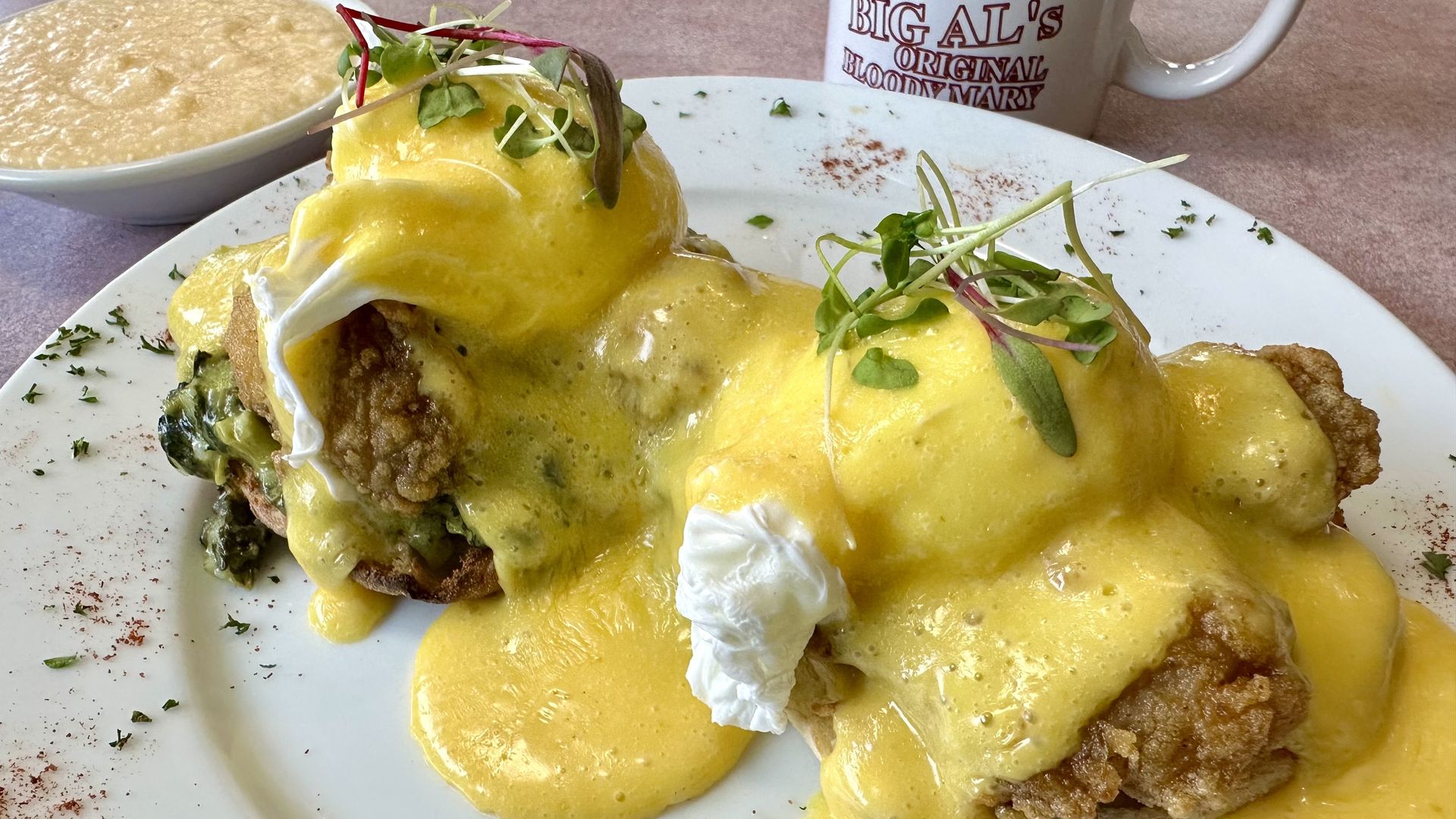 Photo shows a plate of eggs Benedict, cheese grits and coffee