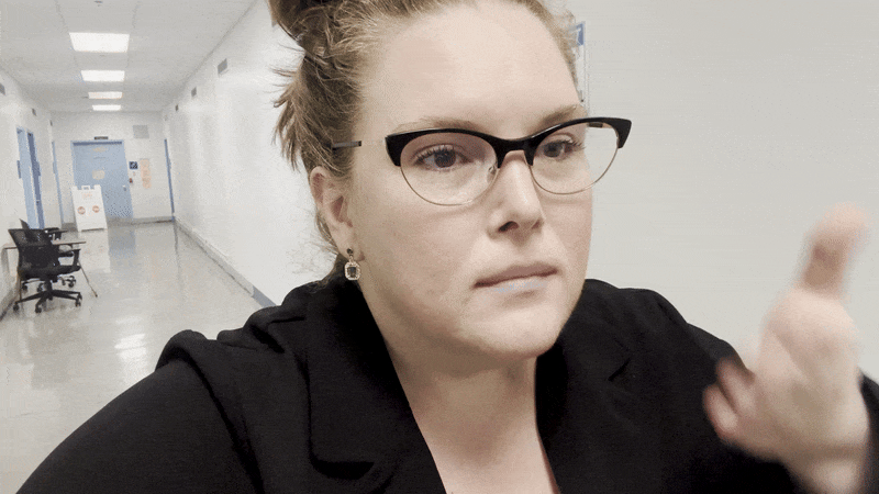 Image shows Carlie wafting air into her face.