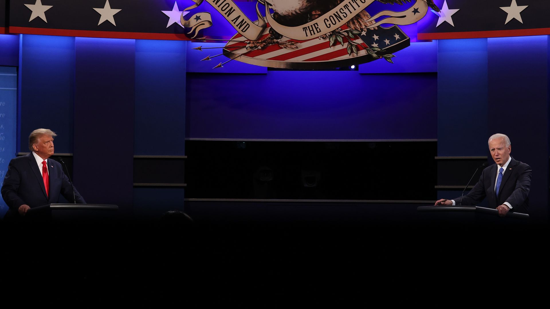 Photo of Donald Trump and Joe Biden facing off on opposing podiums on a debate stage