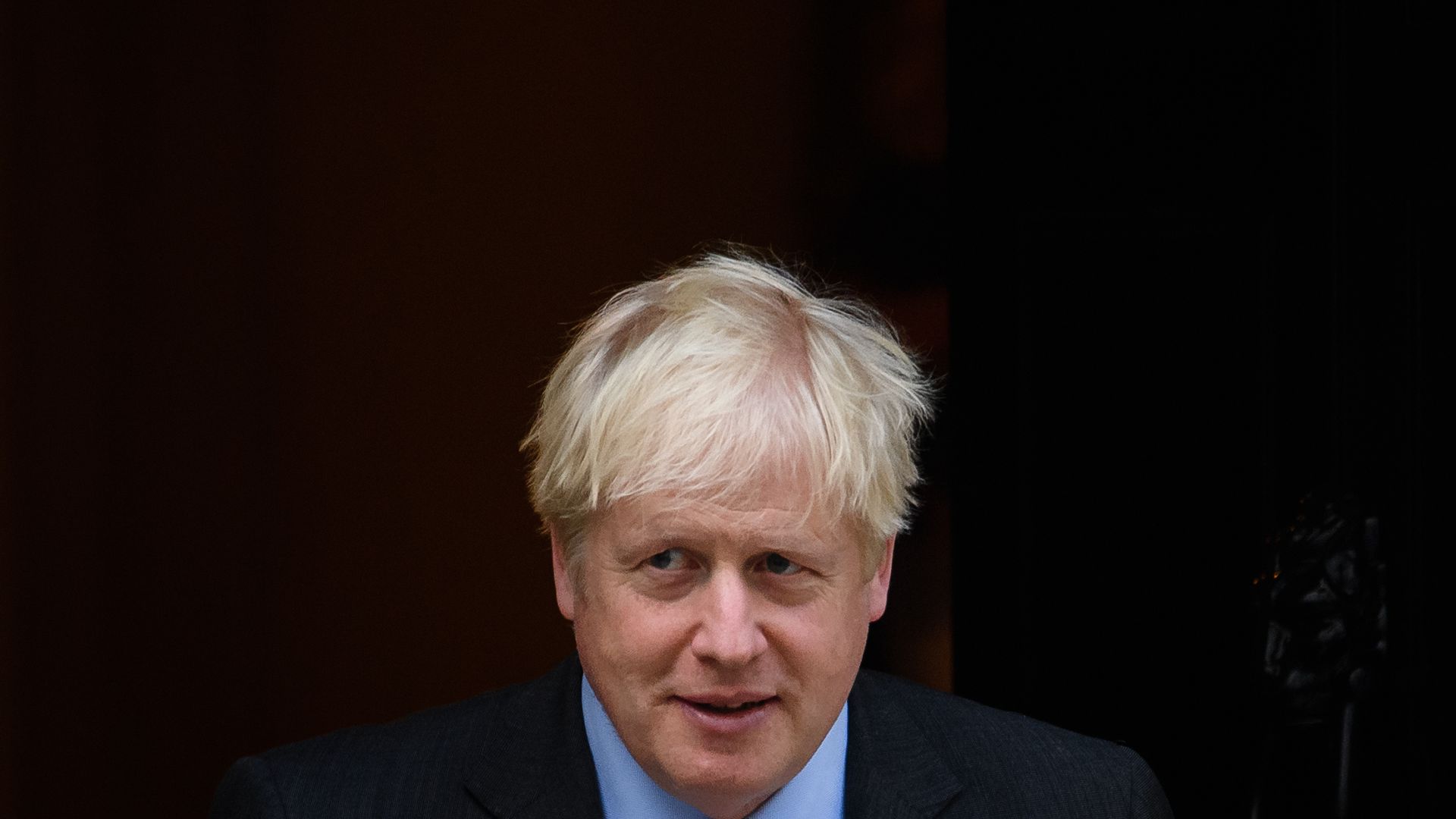 Boris Johnson walks towards the camera while looking to the left