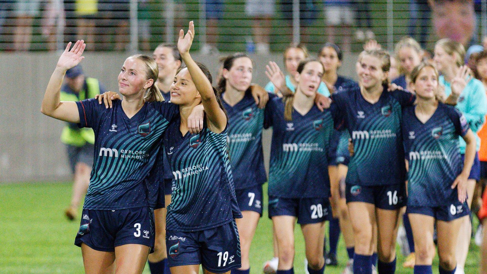 Minnesota Aurors players join arms and wave at fans 